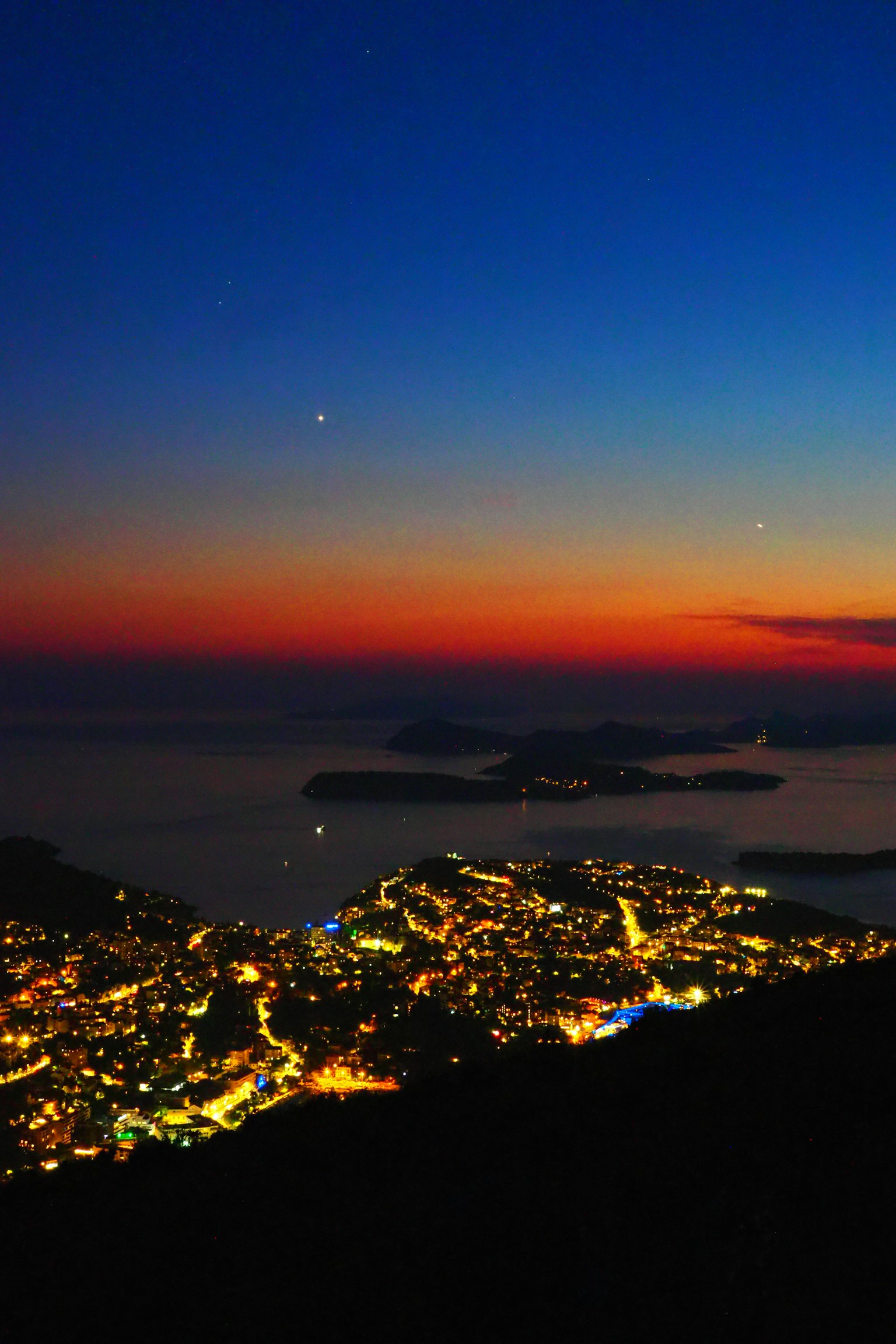 Splendida città costiera di notte con un cielo al tramonto sfumato