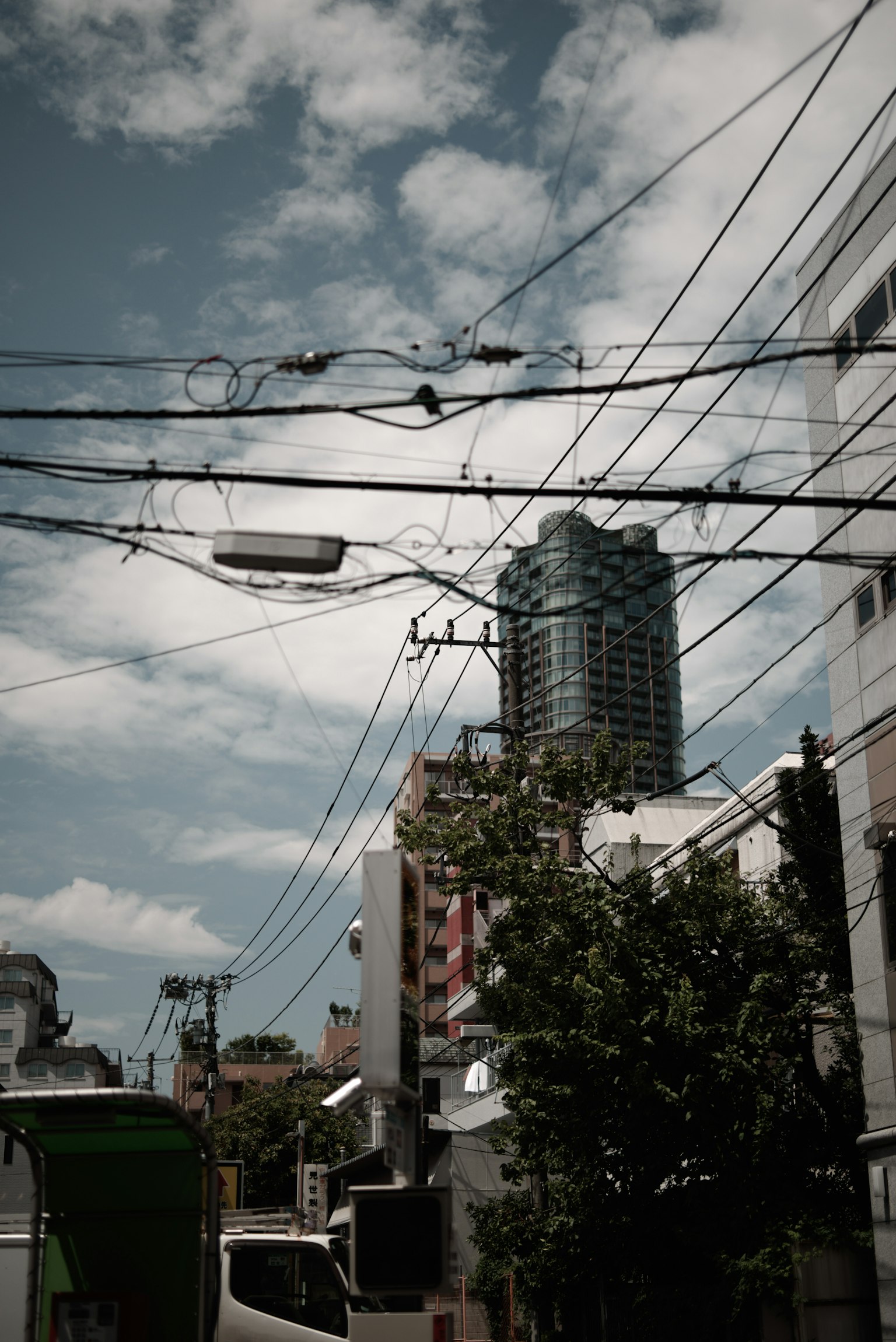 Scène urbaine avec un immeuble de grande hauteur et des lignes électriques croisées