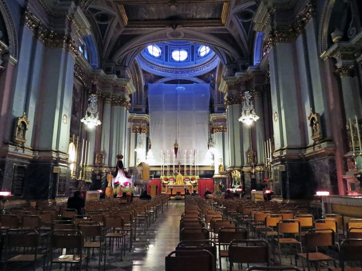 Interior katedral dengan langit-langit tinggi dan dekorasi indah dengan deretan kursi