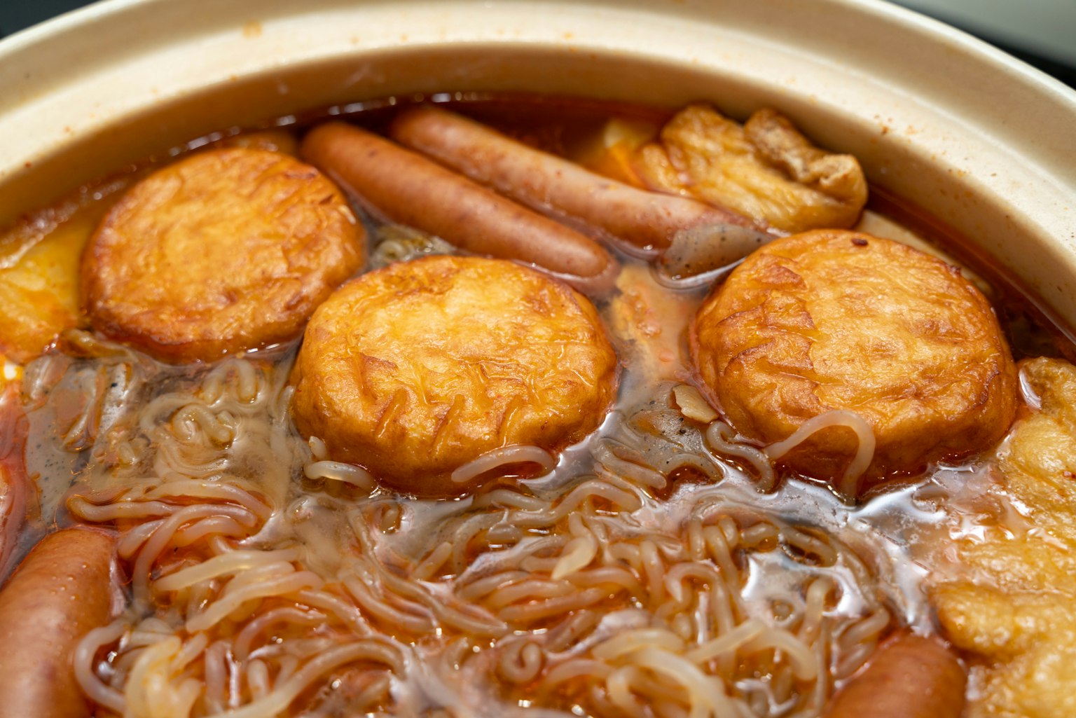Plat chaud avec des nouilles et des gâteaux de poisson frits