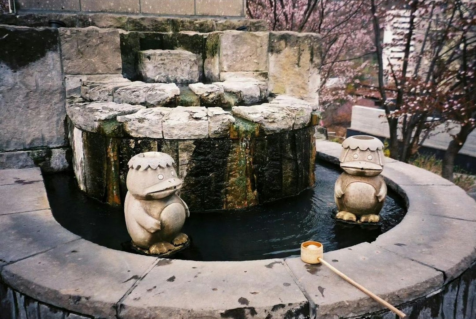 Fontana in pietra con due statue carine e acqua che scorre
