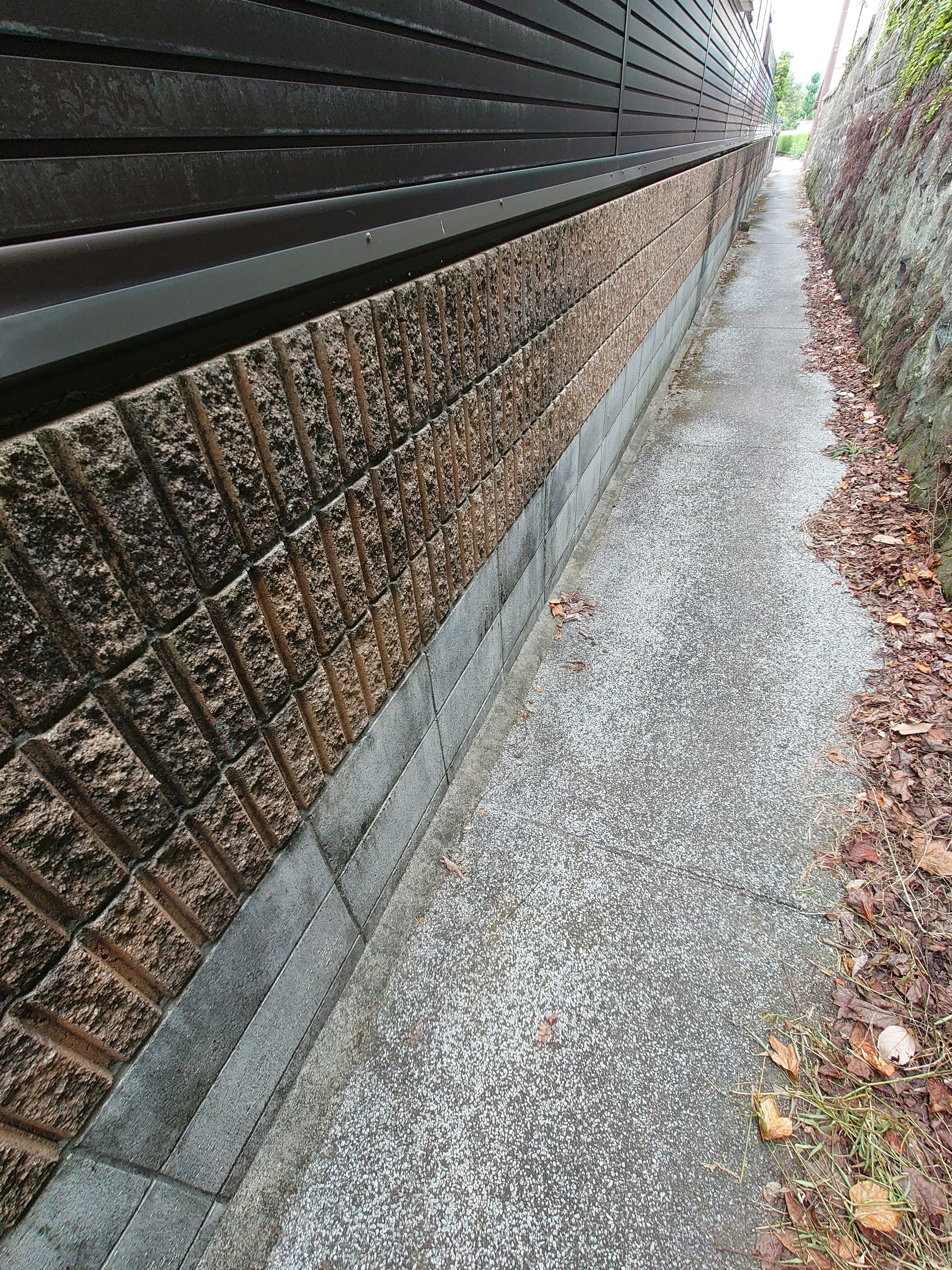 路地裏の石積みの壁と細い小道