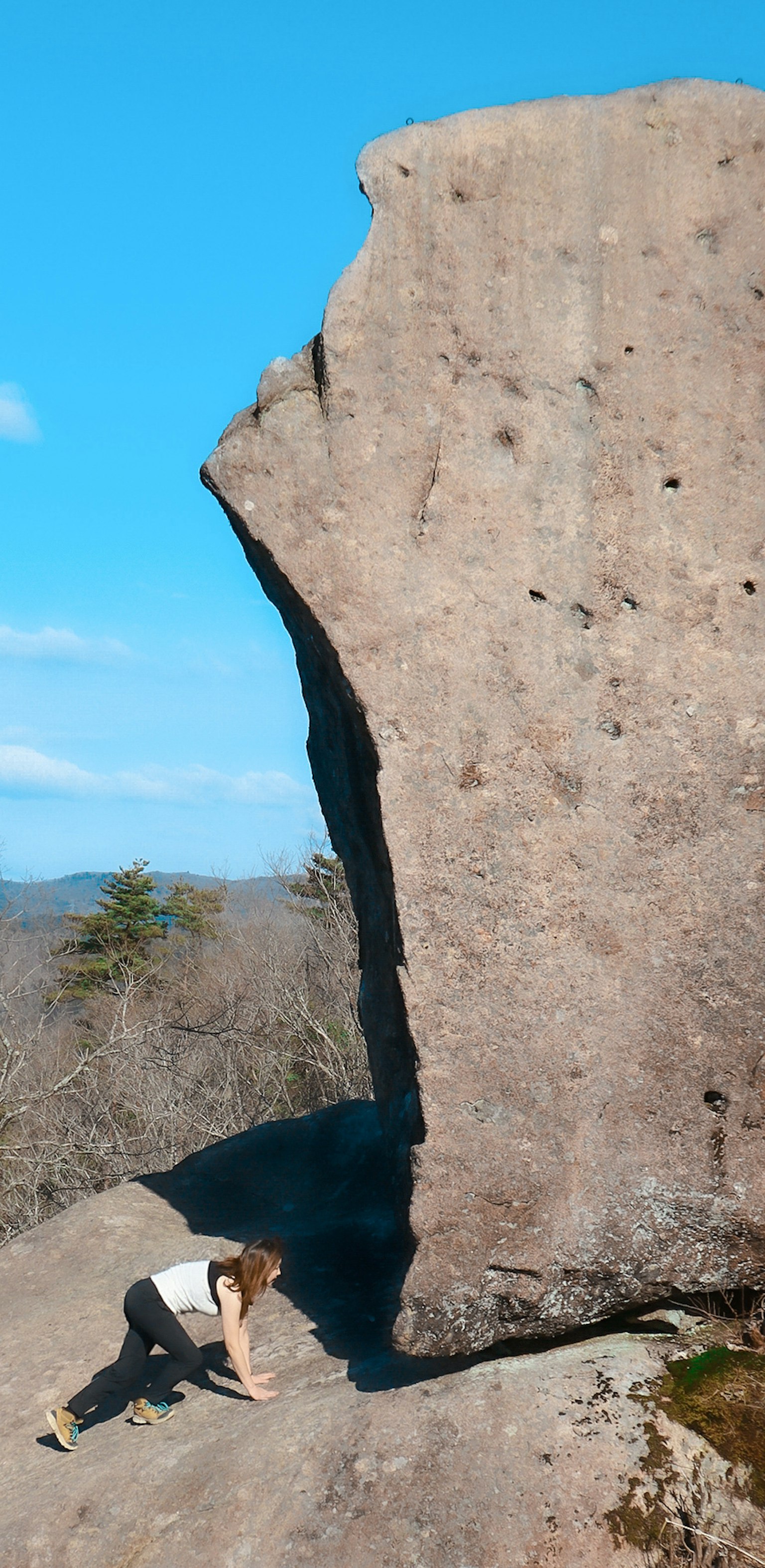 A person climbing near a large rock formation