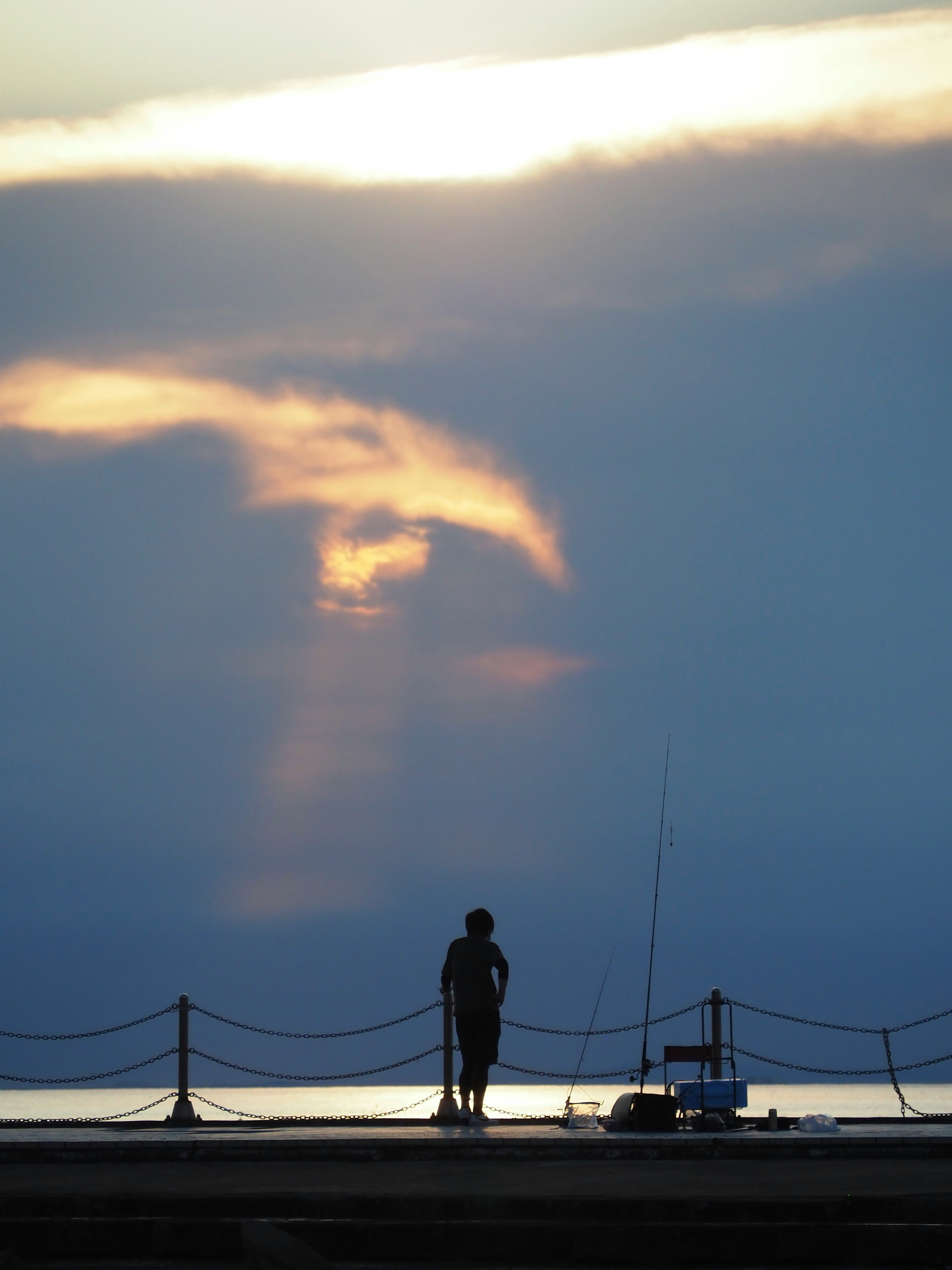 夕暮れの空を見上げる一人のシルエット