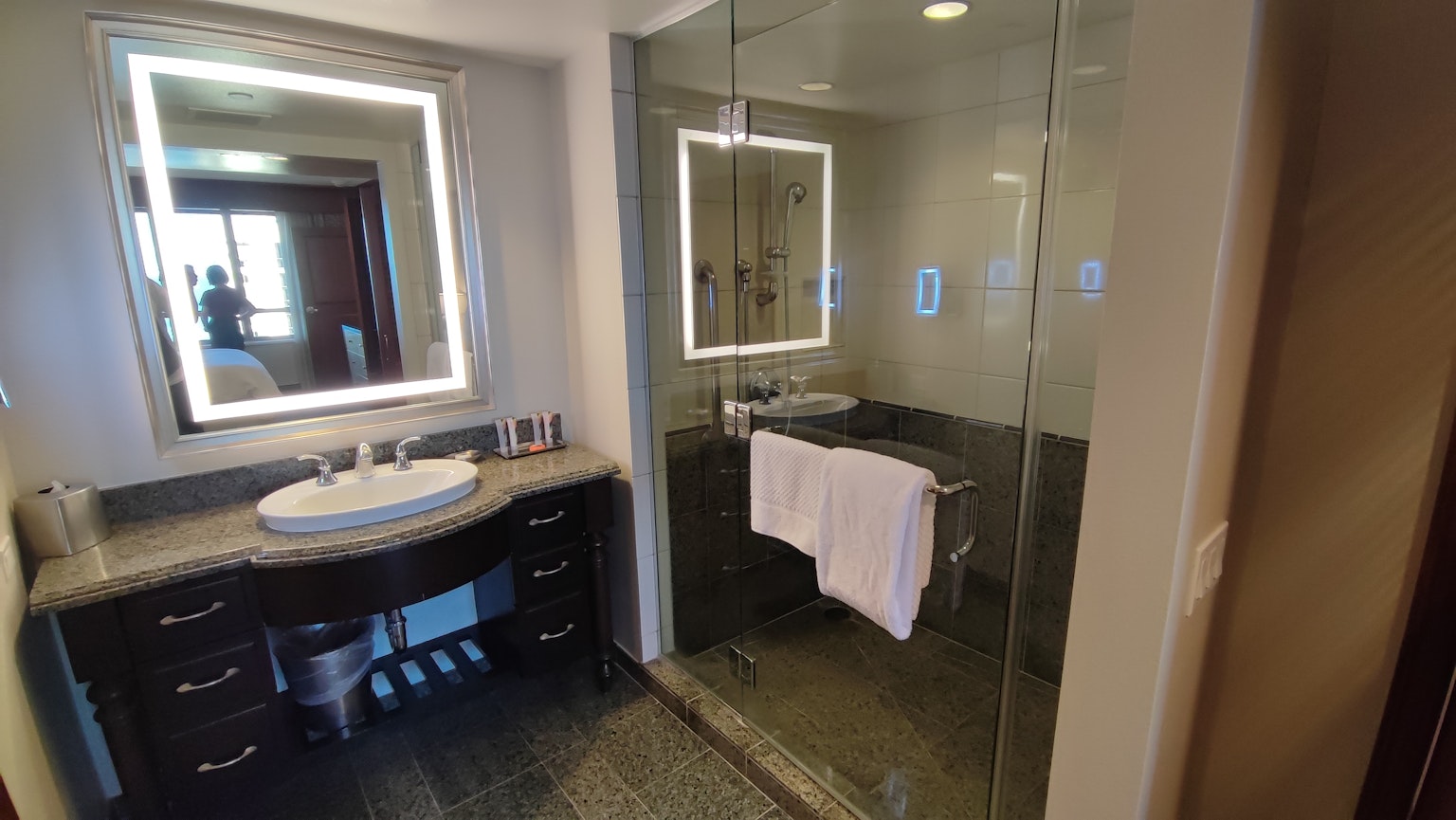 Interno di bagno moderno con lavabo elegante area doccia in vetro specchio illuminato