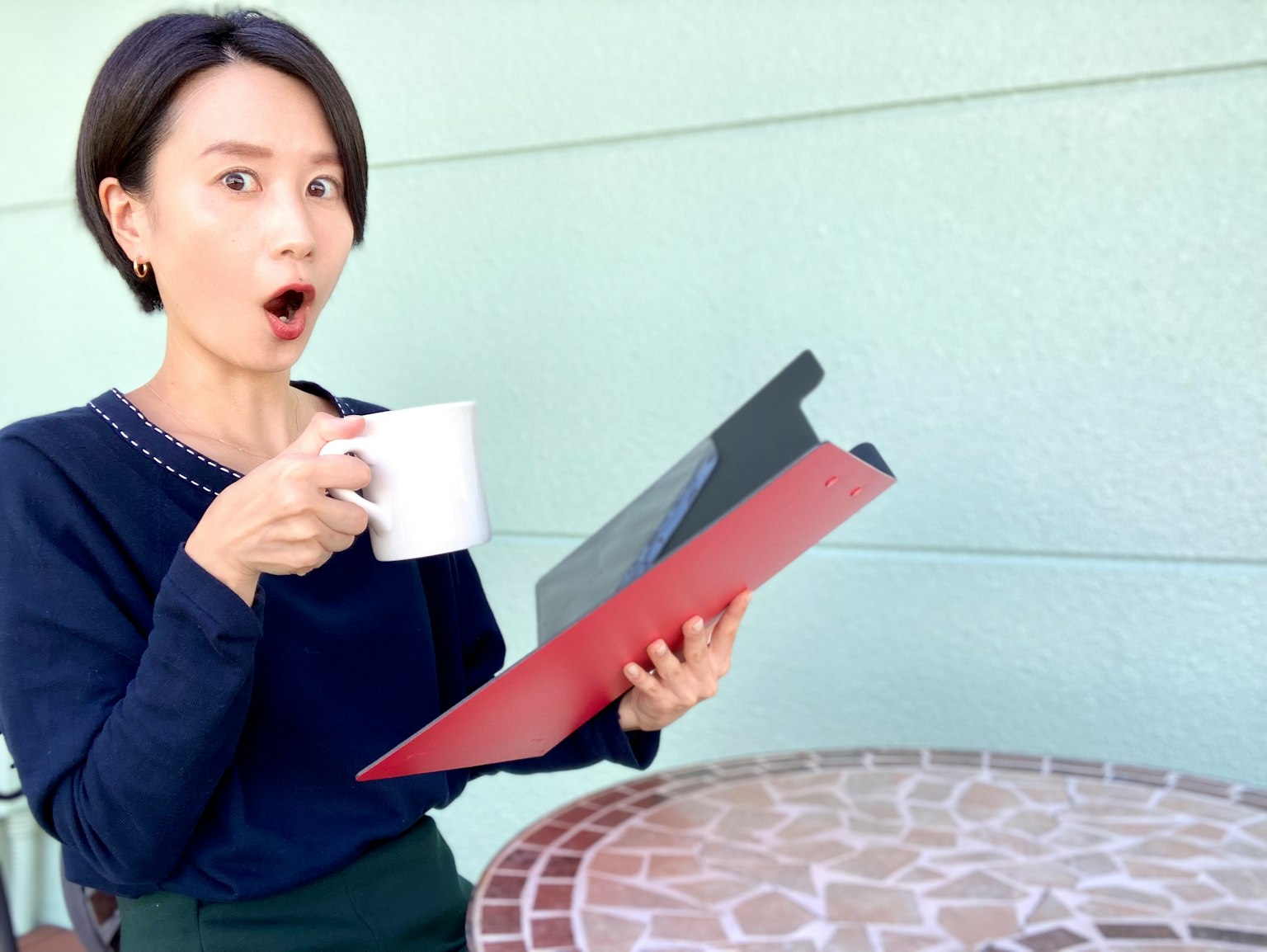 Surprised woman holding a menu while drinking coffee at a cafe