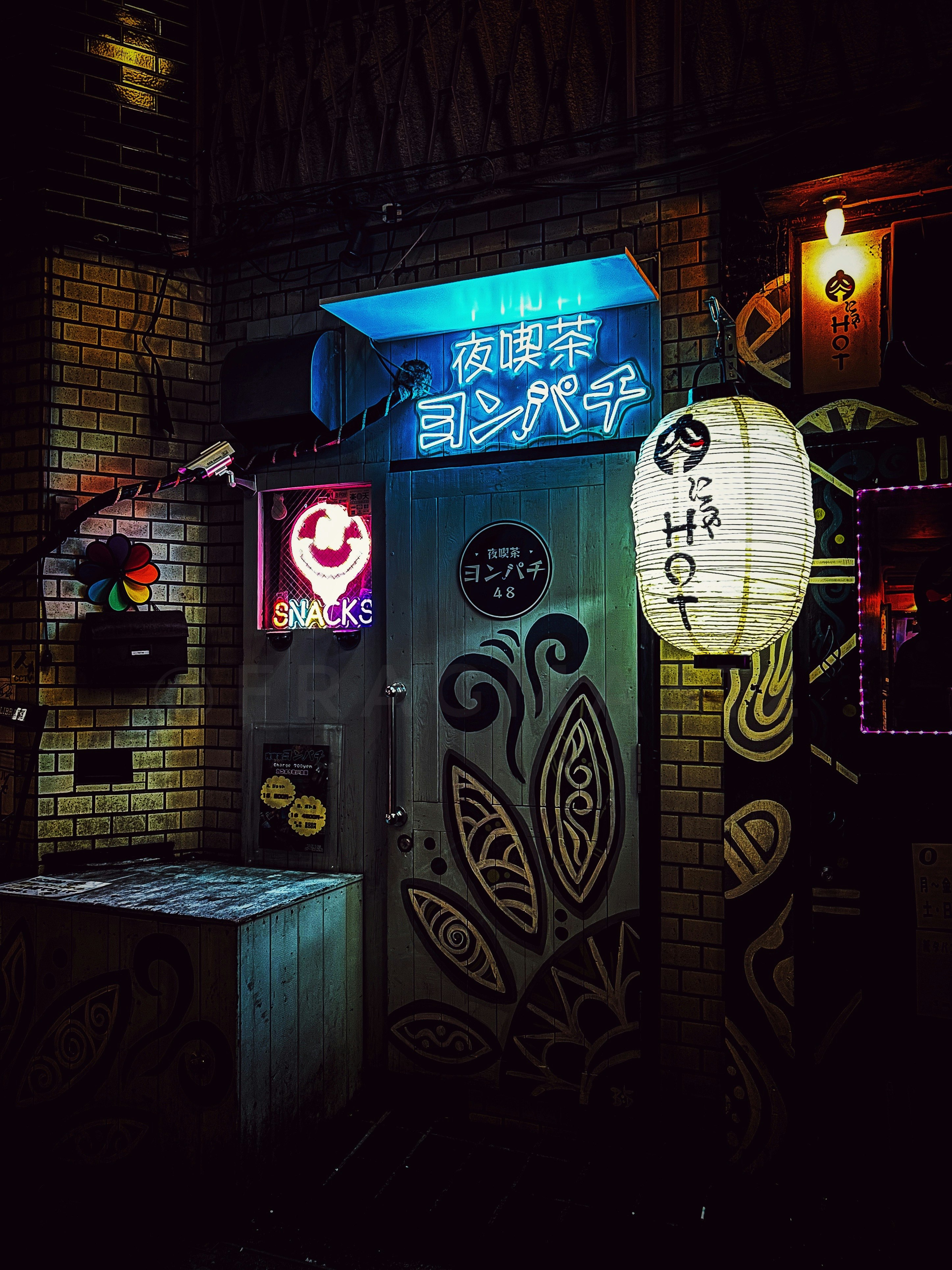夜のレンガ壁に光る看板とスナック店の入口