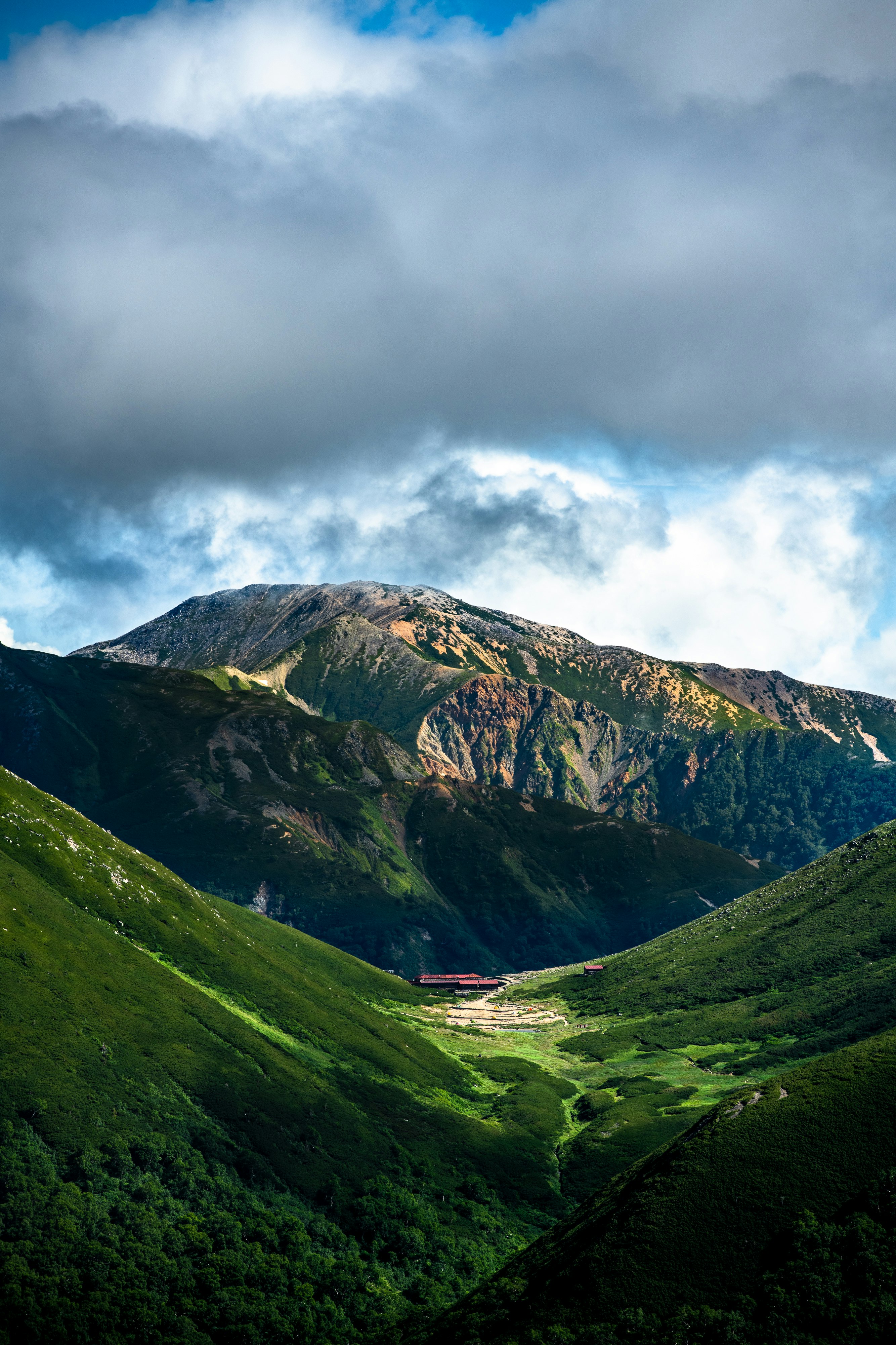 緑の山々と谷を覆う雲の下の渓谷風景