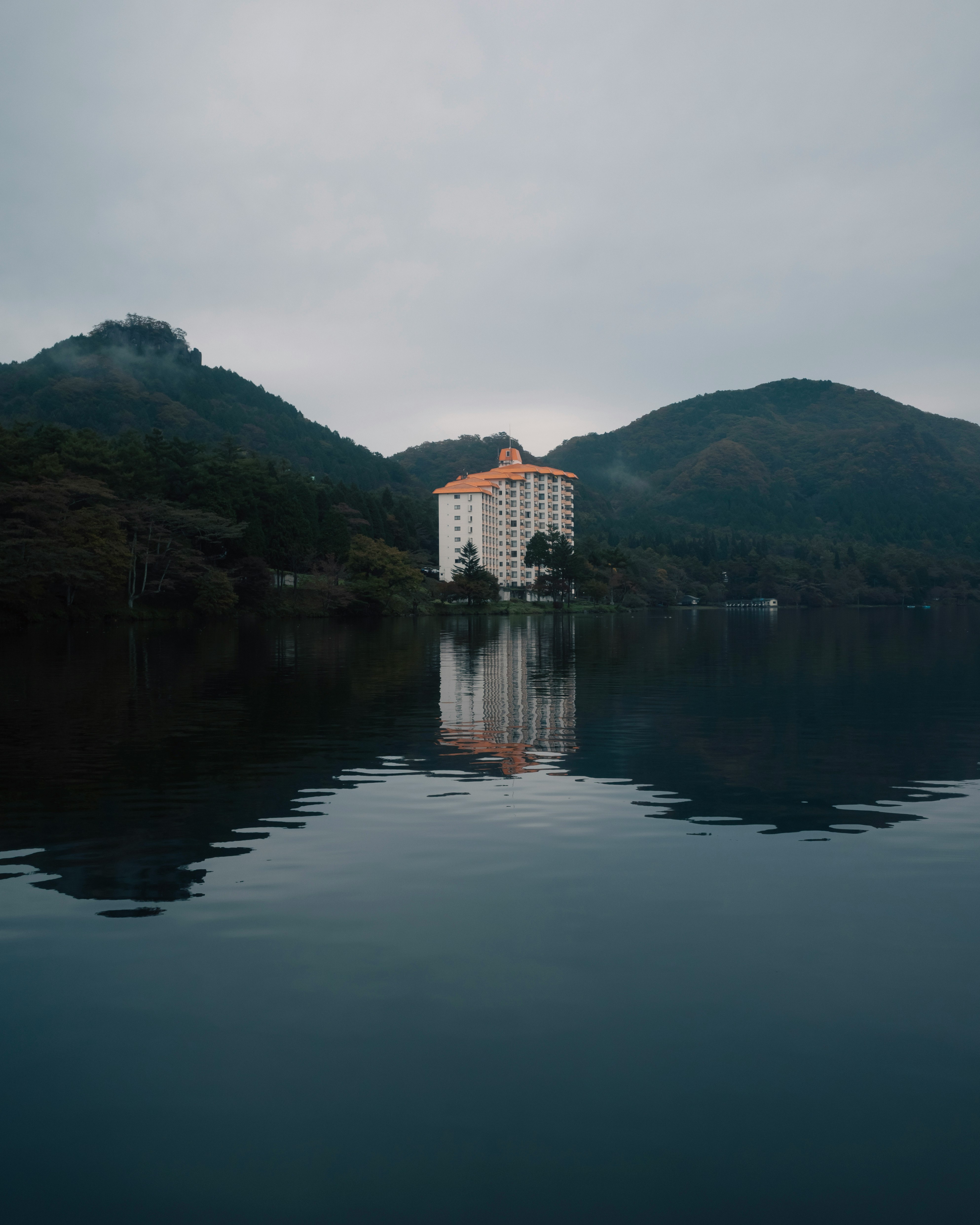 湖面に映る山あいのホテルと静かな水景