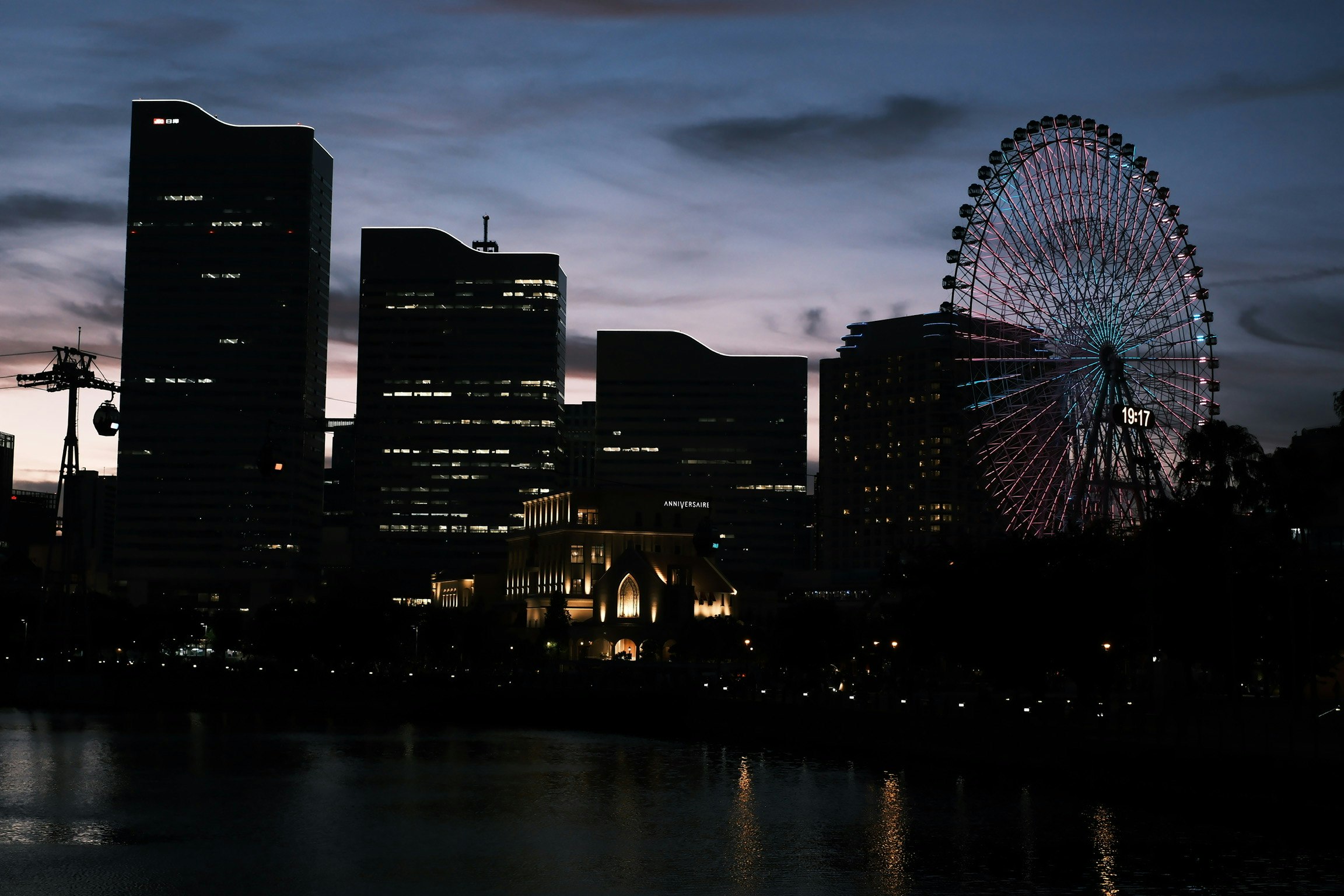 夜景の観覧車と高層ビルが並ぶ港の街並み