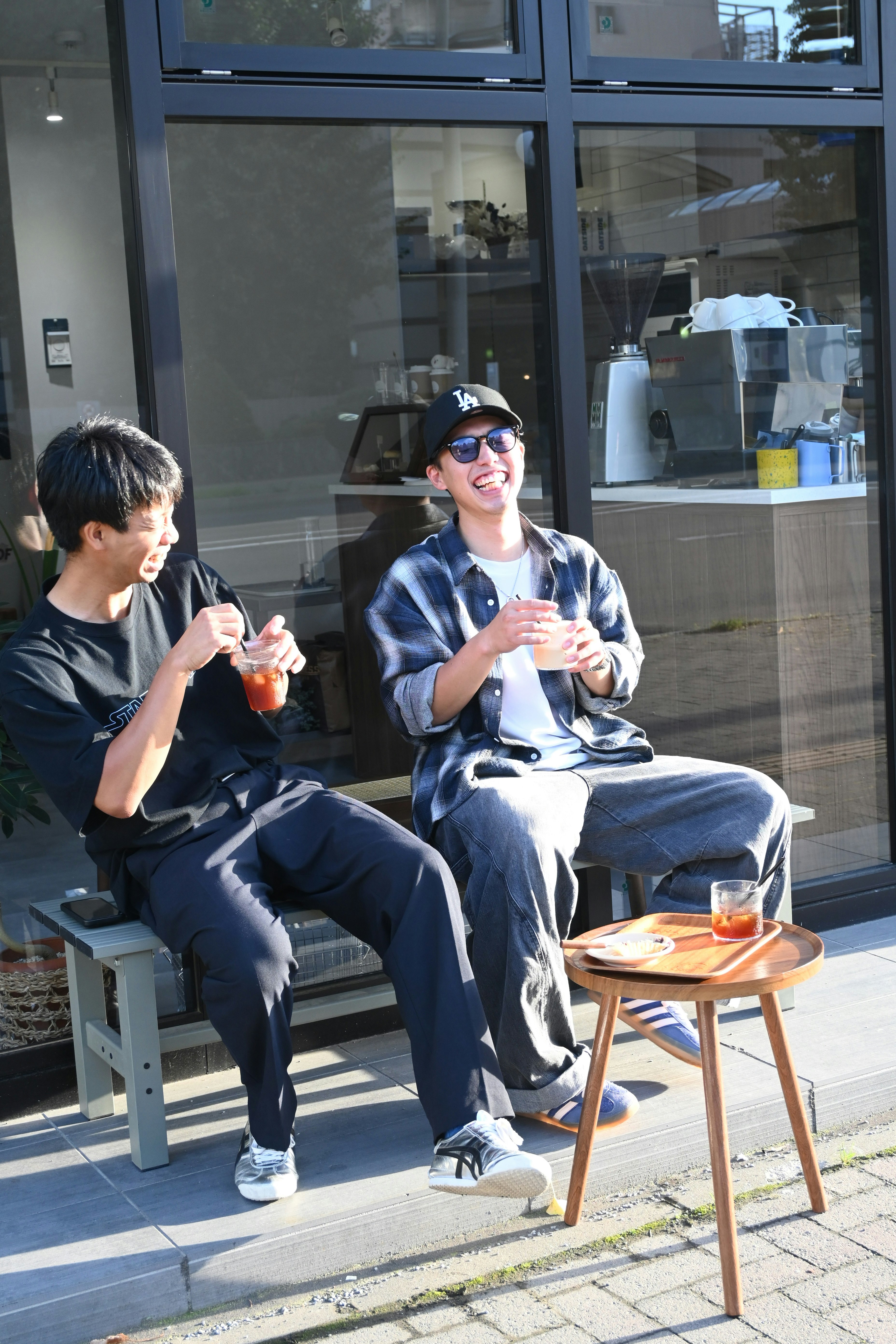 新しいカフェのテラス席で男3人がコーヒーを飲みながら会話するひととき