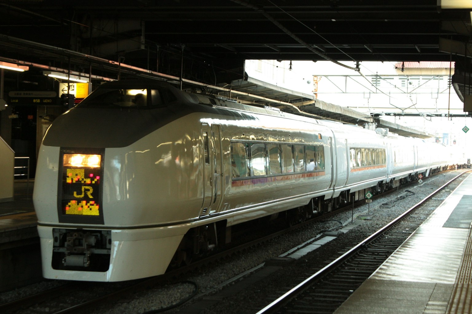 Sebuah kereta putih berhenti di stasiun