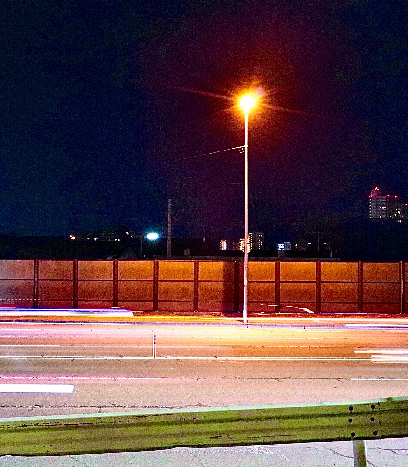 街灯の光がにじむ夜の道路風景