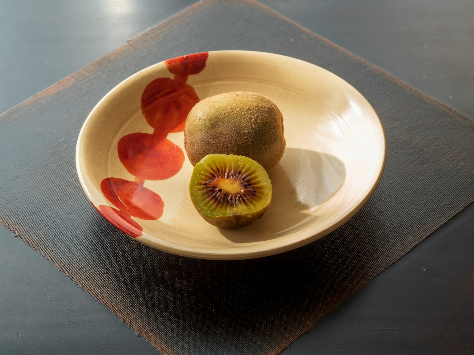 Un piatto in ceramica con kiwi e patate