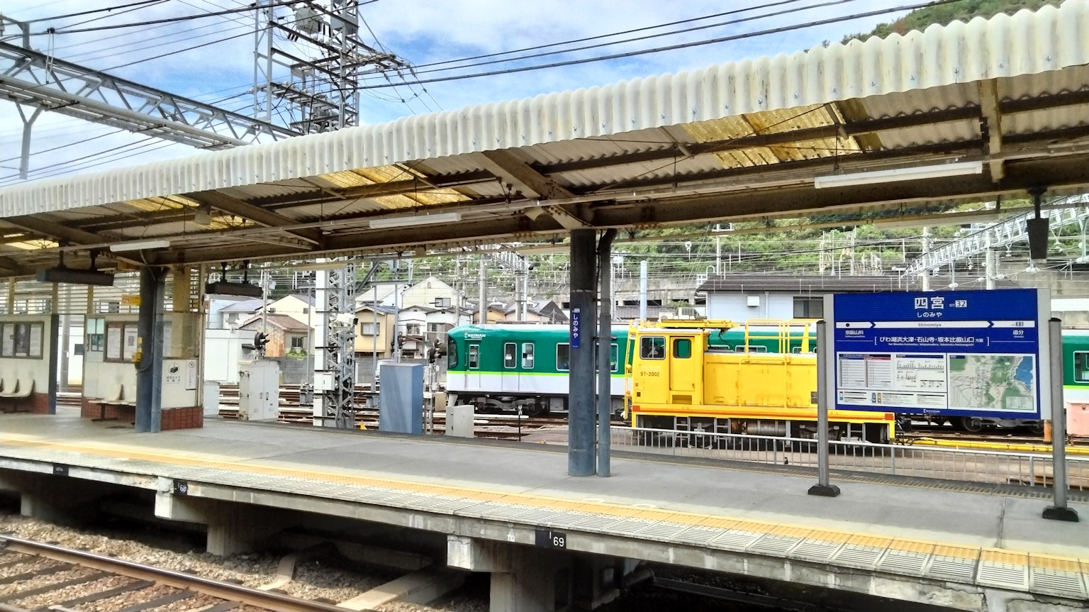 ชานชาลาสถานีรถไฟที่มีรถไฟจอดและป้ายข้อมูล
