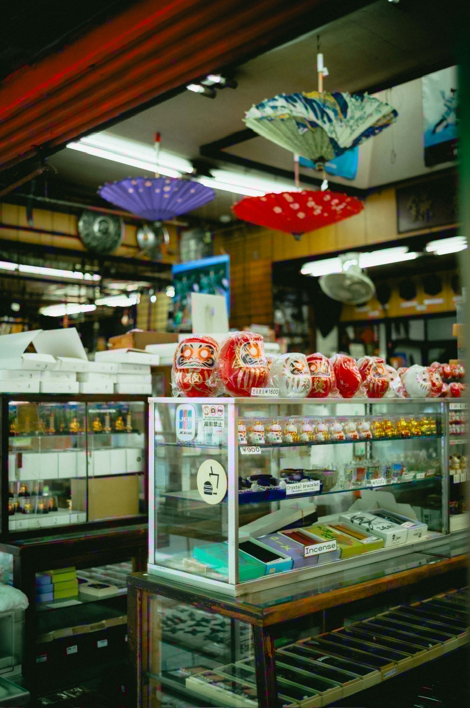 伝統的な商店の内部にあるガラスケースとカラフルな傘の装飾