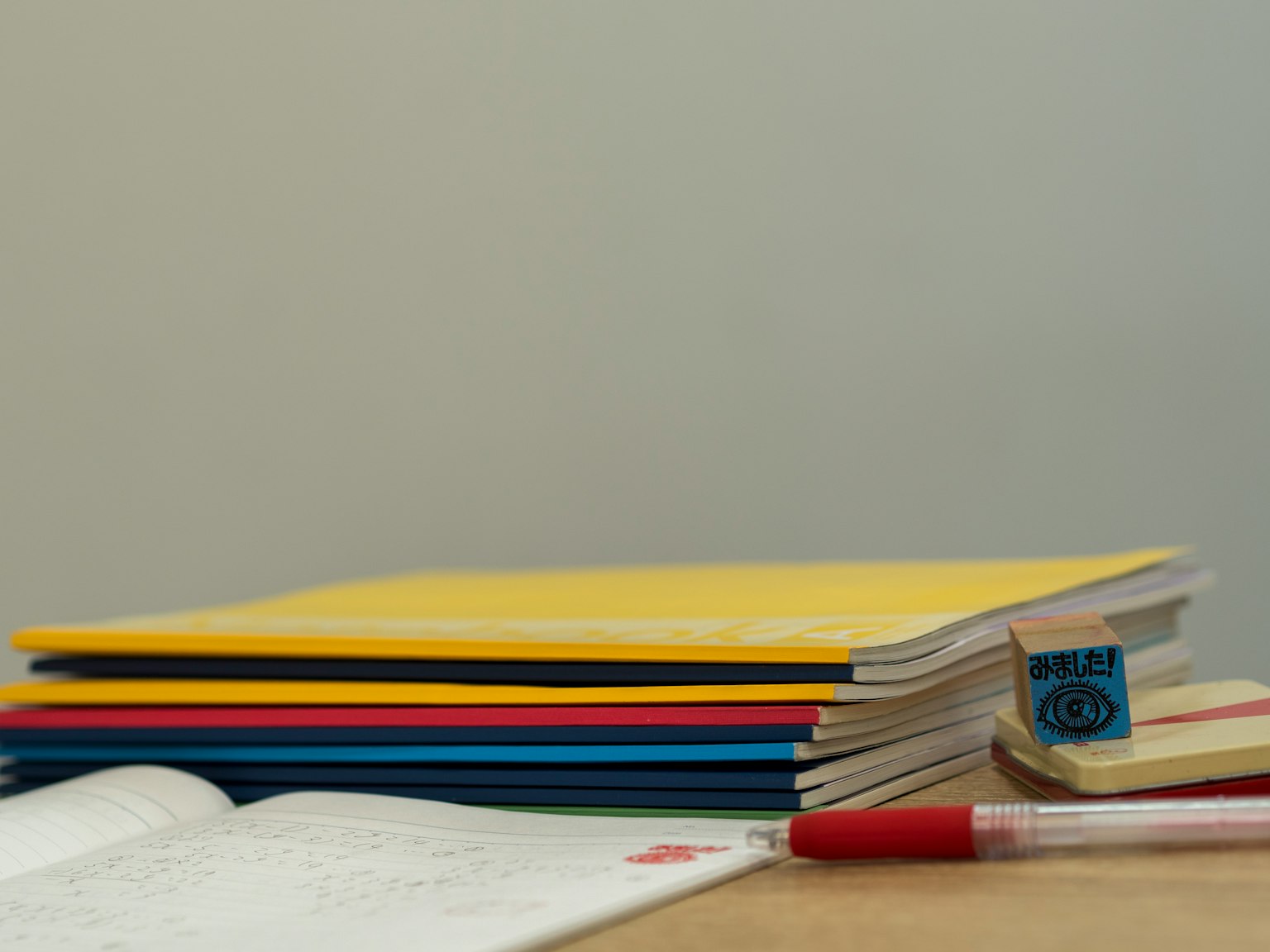 Colorful notebooks and stationery stacked on a desk