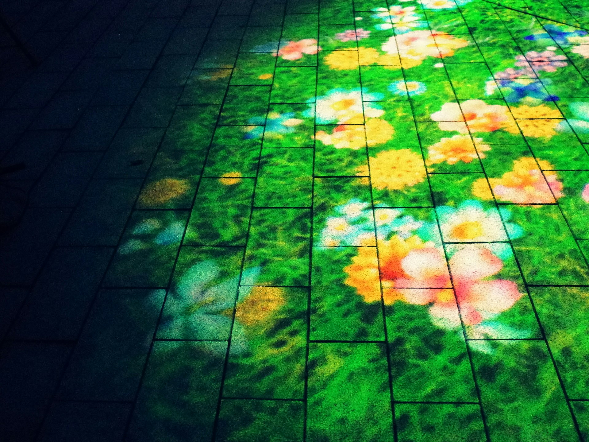 bunte Wolkenprojektion auf einem grünen Fliesenboden