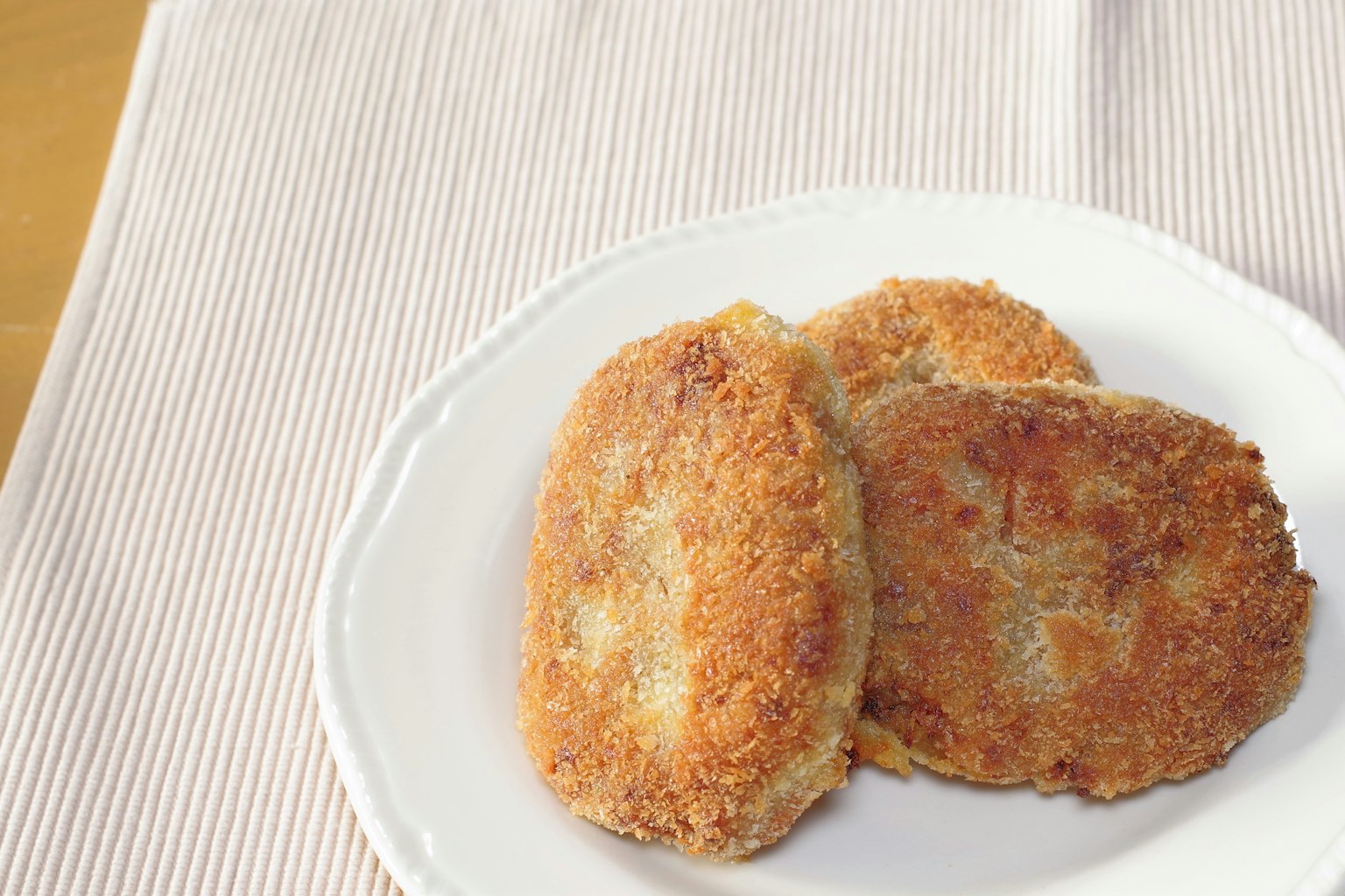 Three breaded cutlets arranged on a plate
