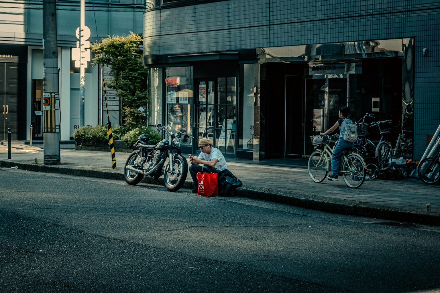 거리에 앉아 있는 남성과 근처의 자전거가 있는 장면