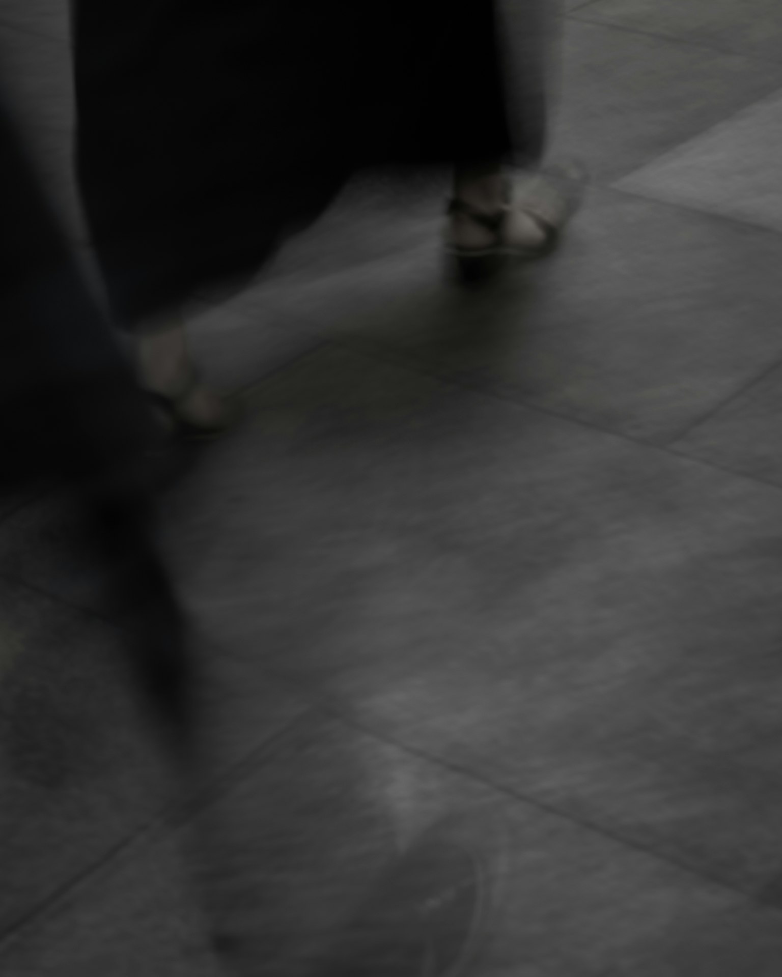 Imagen borrosa de pies en movimiento sobre un suelo