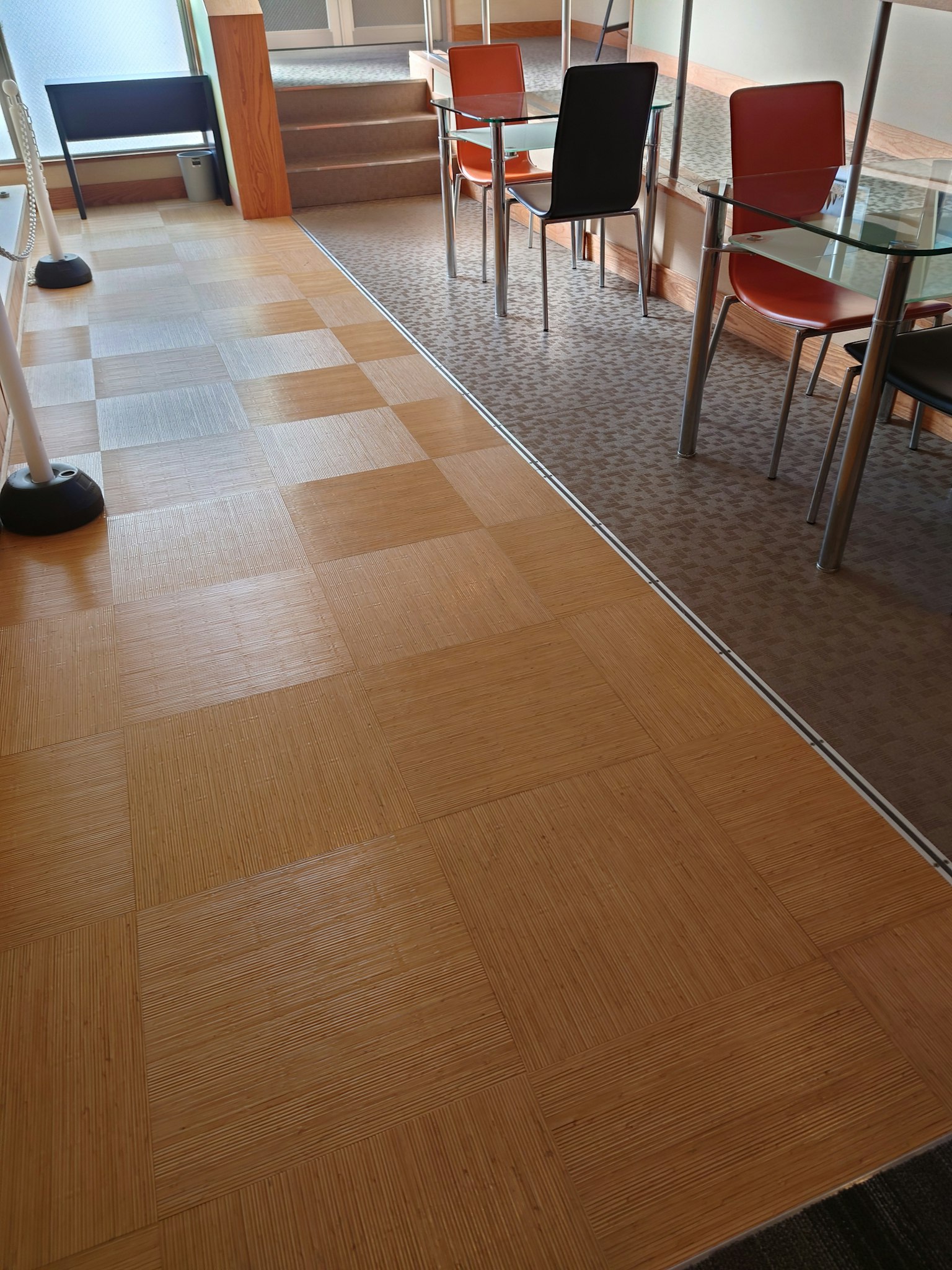 Pavimento in legno chiaro e moquette in uno spazio ufficio