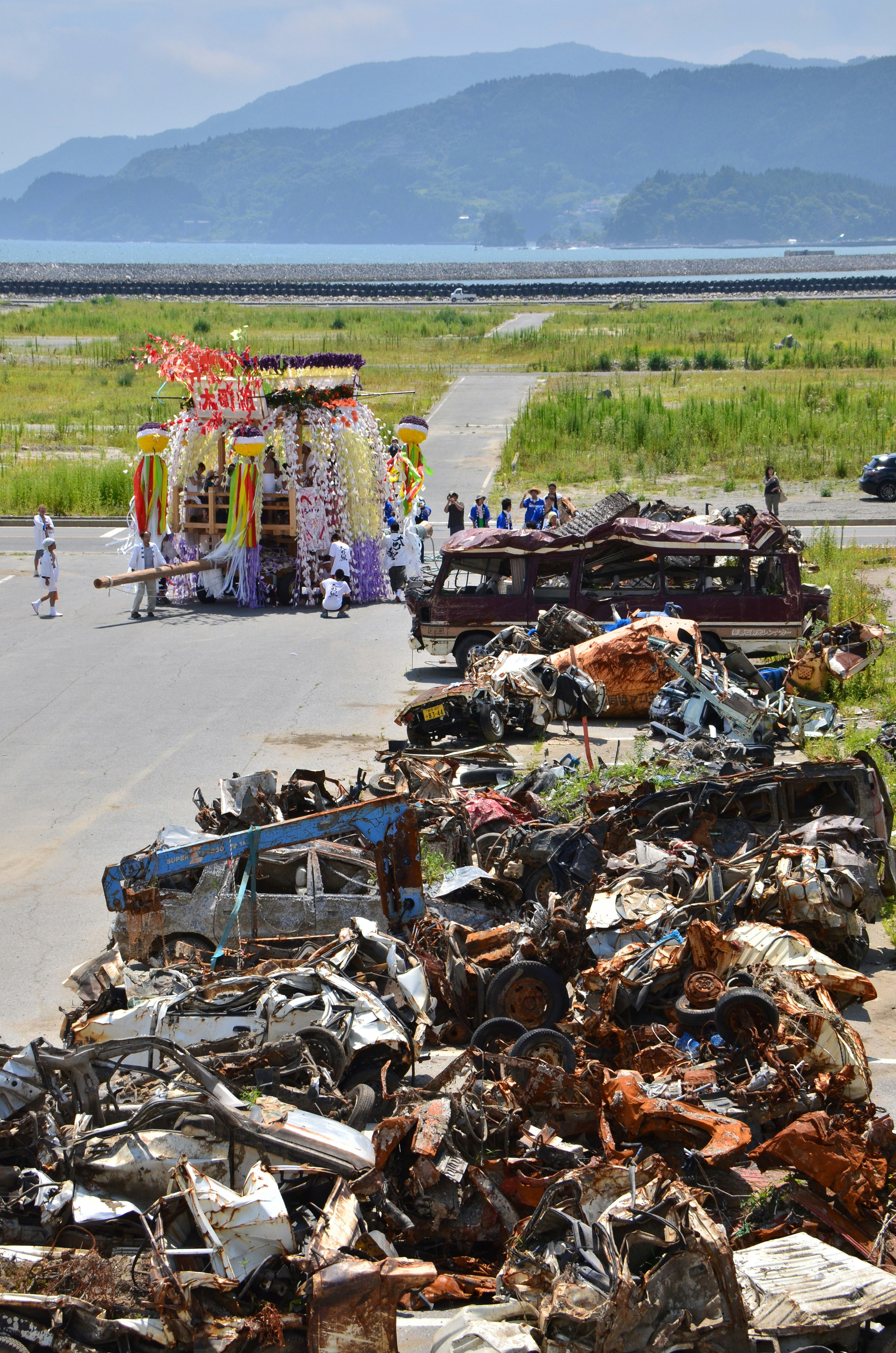 海沿いの堤防で並ぶ廃棄物とリサイクル作業の屋台
