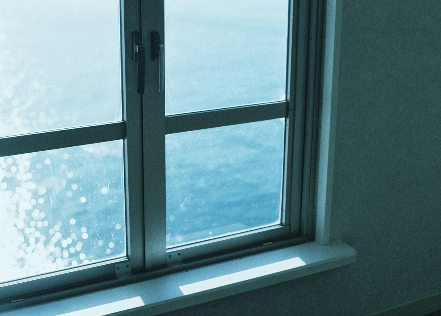 Vista interior cerca de una ventana con vista al mar azul