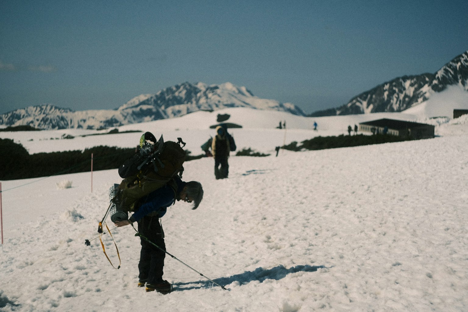 눈으로 덮인 풍경을 탐험하는 등산객과 멀리 있는 산들