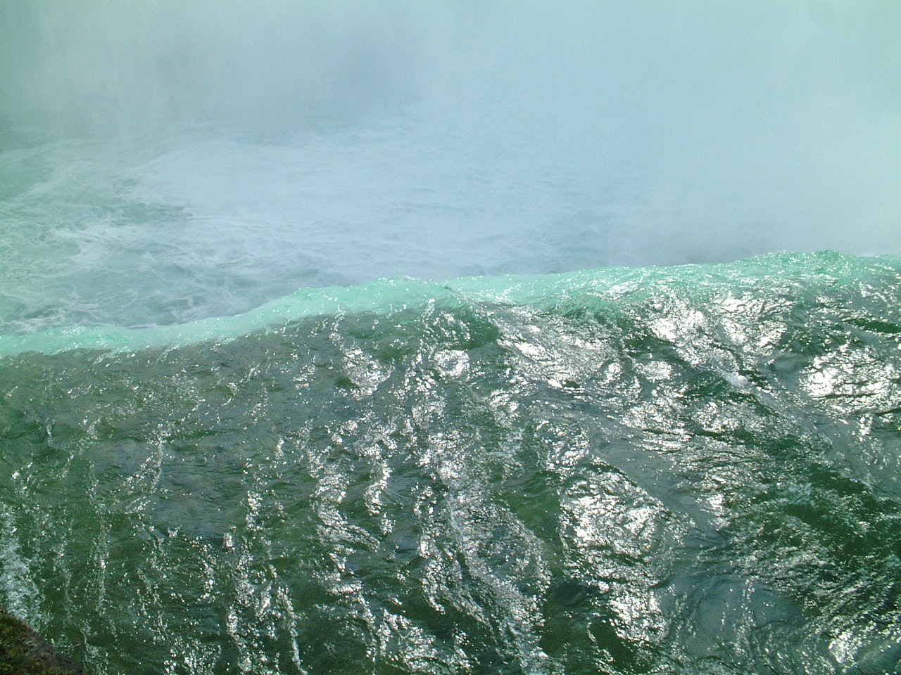 green-tinted ocean waves churning with foam