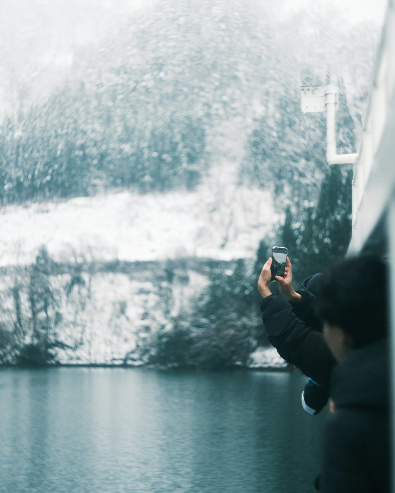 Người chụp ảnh bằng smartphone trước khung cảnh tuyết rơi