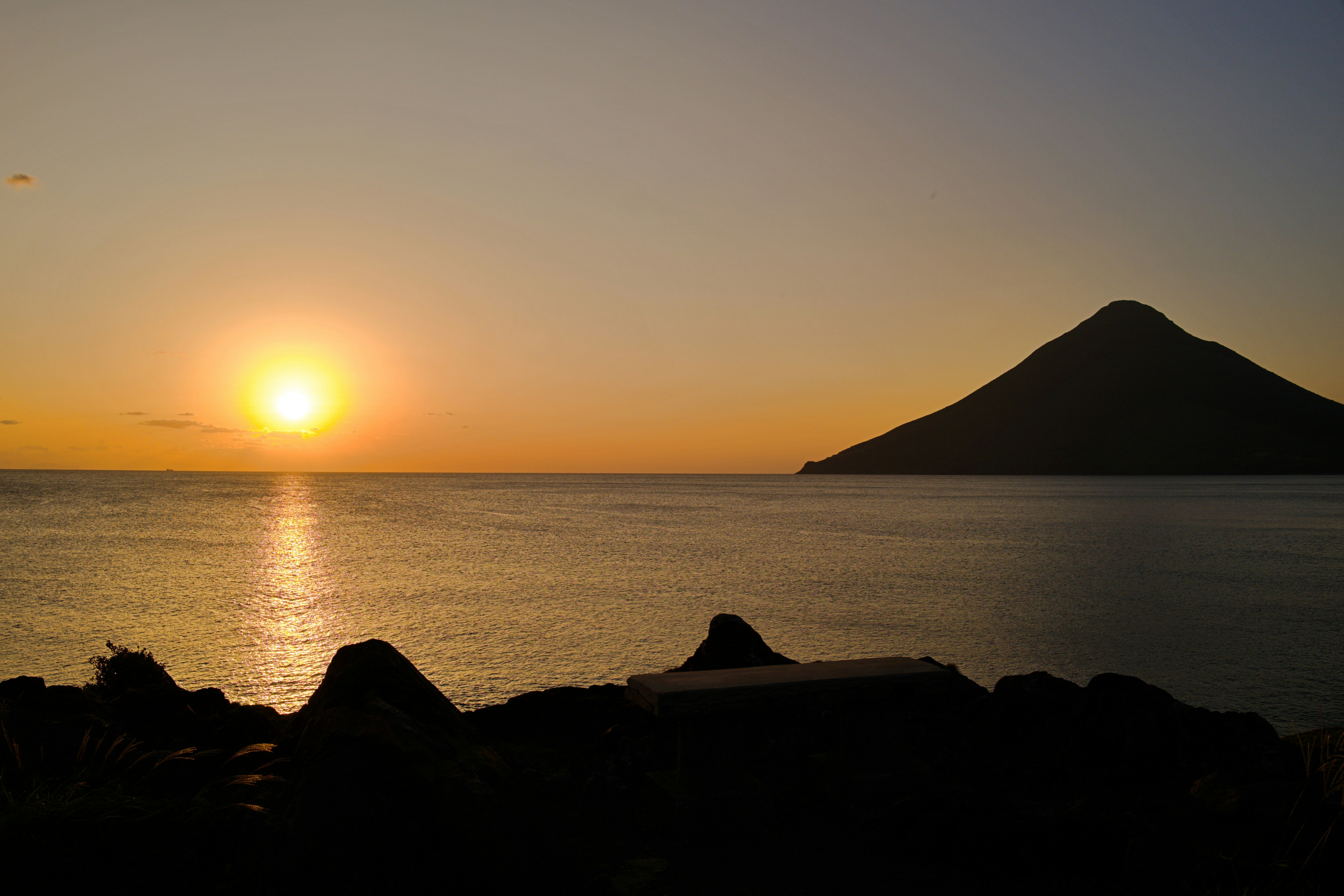 atardecer sobre el mar con una isla en silueta