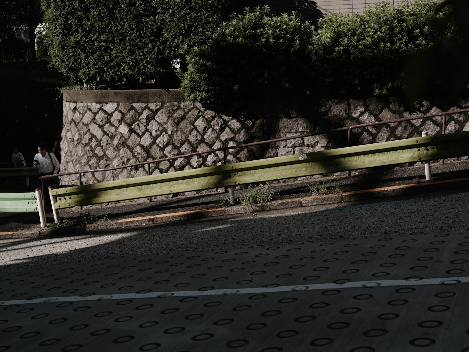 Con đường cong với tường đá và cây xanh tươi