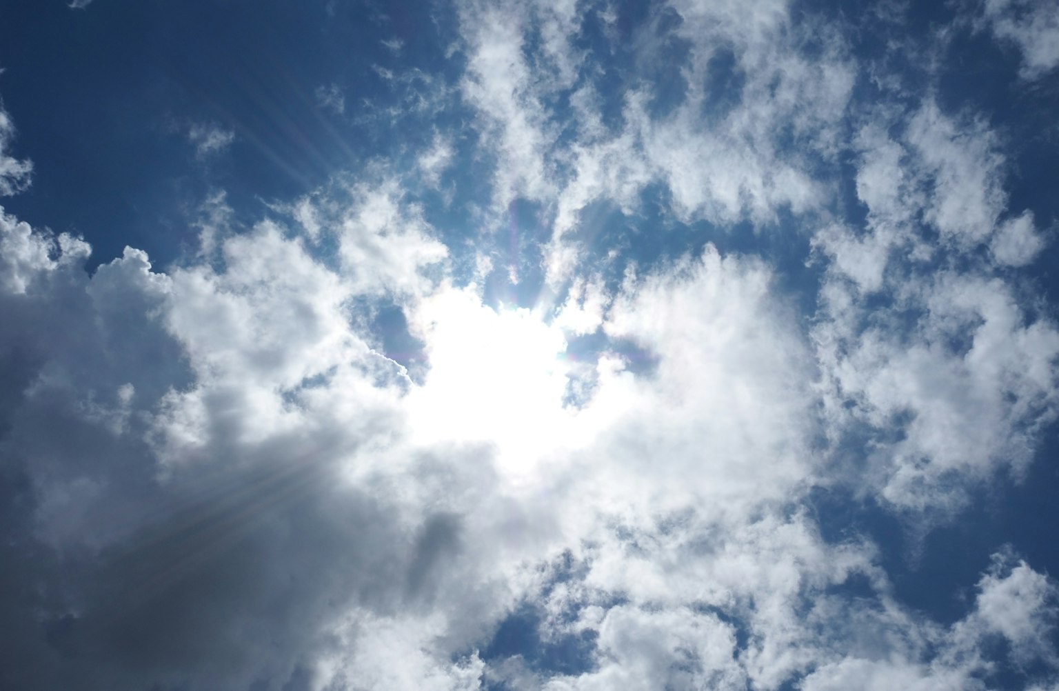 Luce del sole che filtra tra le nuvole in un cielo blu
