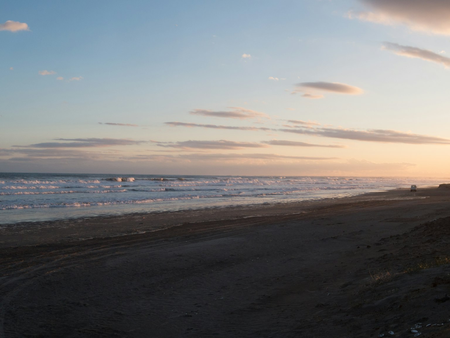 Coastal landscape at sunset with calm ocean and sandy beach