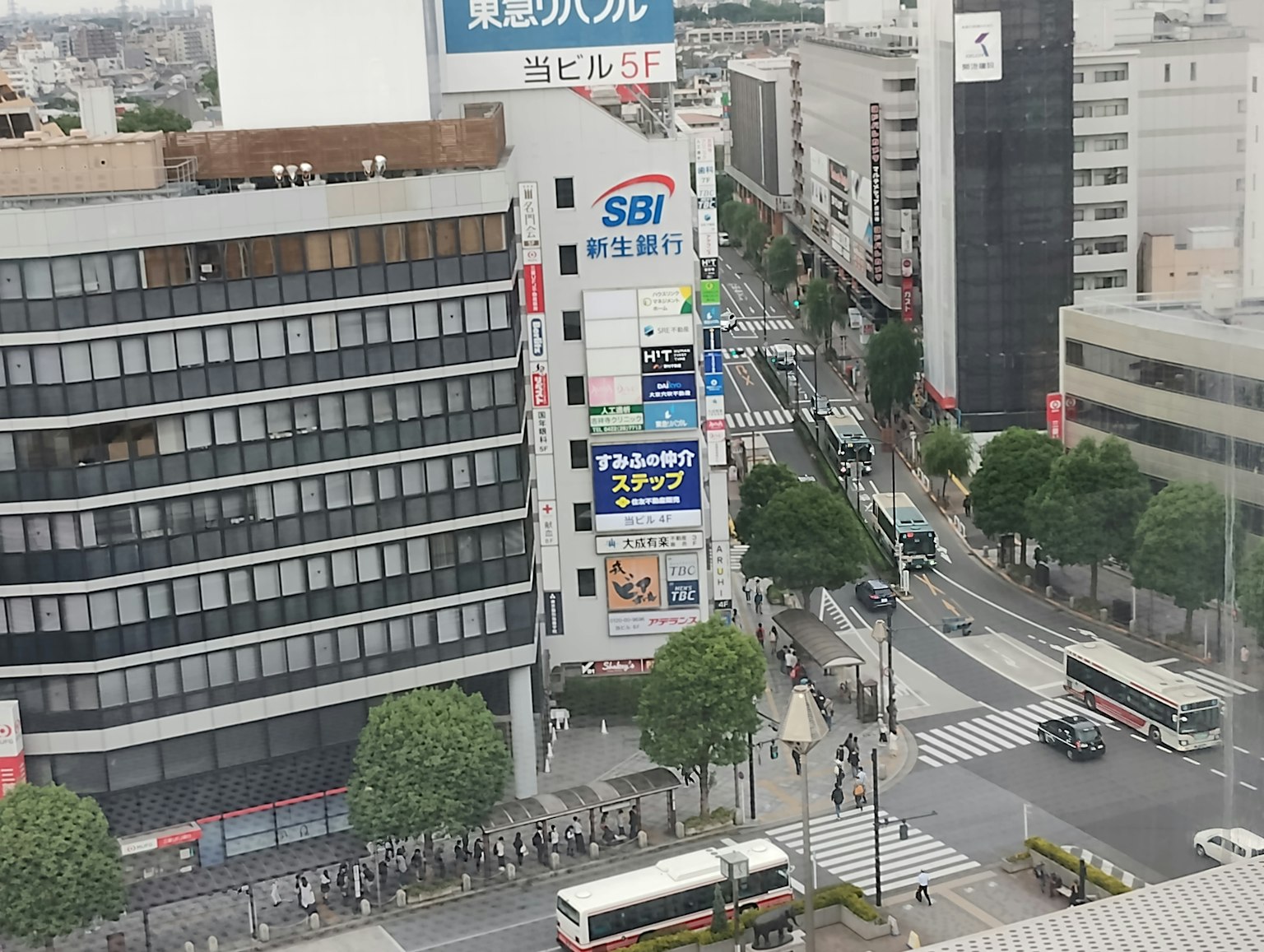 Pemandangan kota dengan papan nama SBI dan aktivitas jalan yang ramai