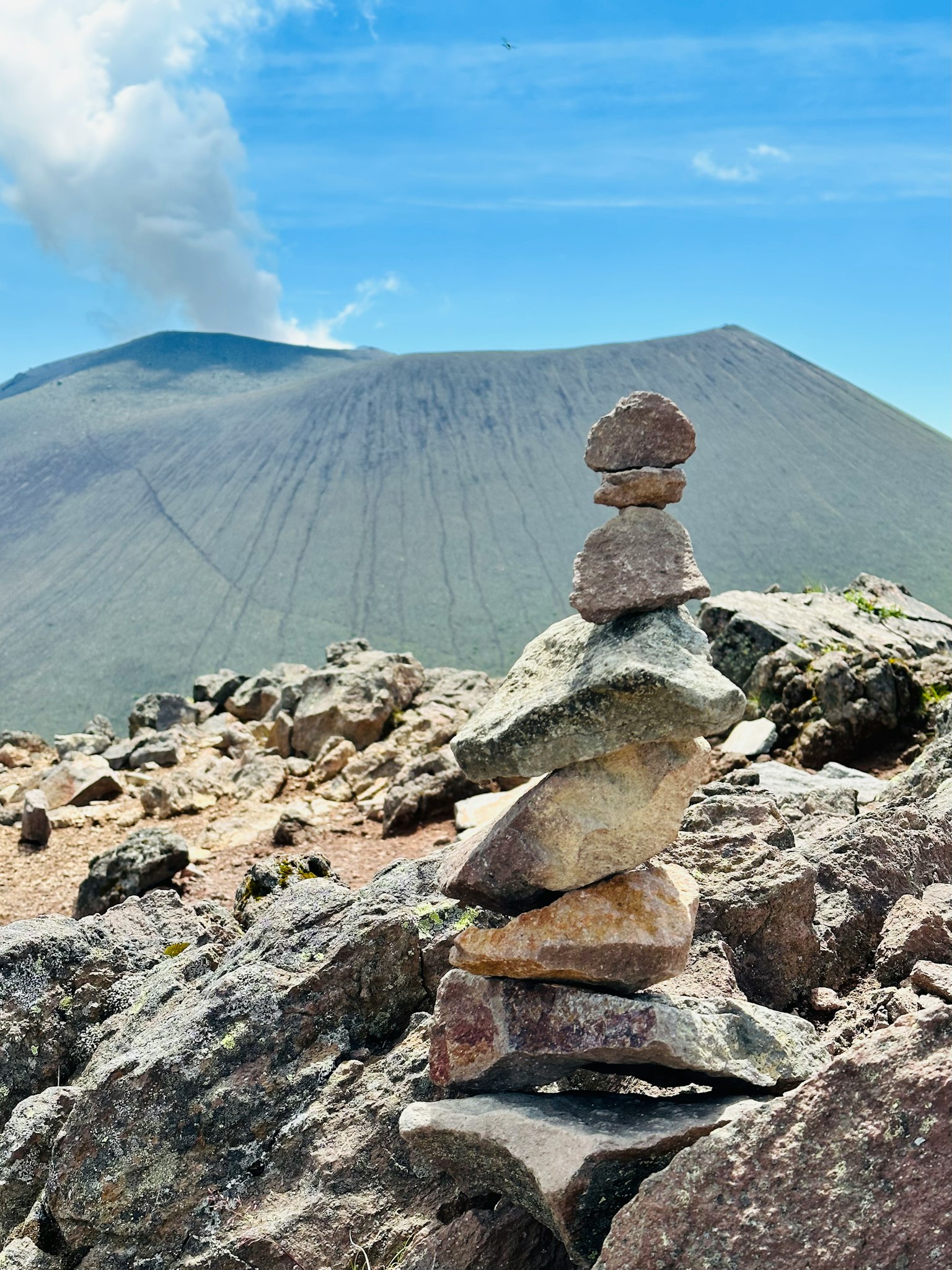 山上的石头堆和背景中的火山