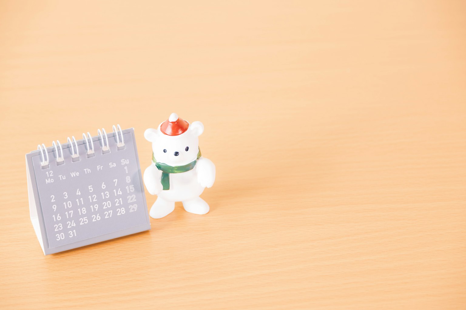 Sebuah kalender dan patung beruang putih di atas meja