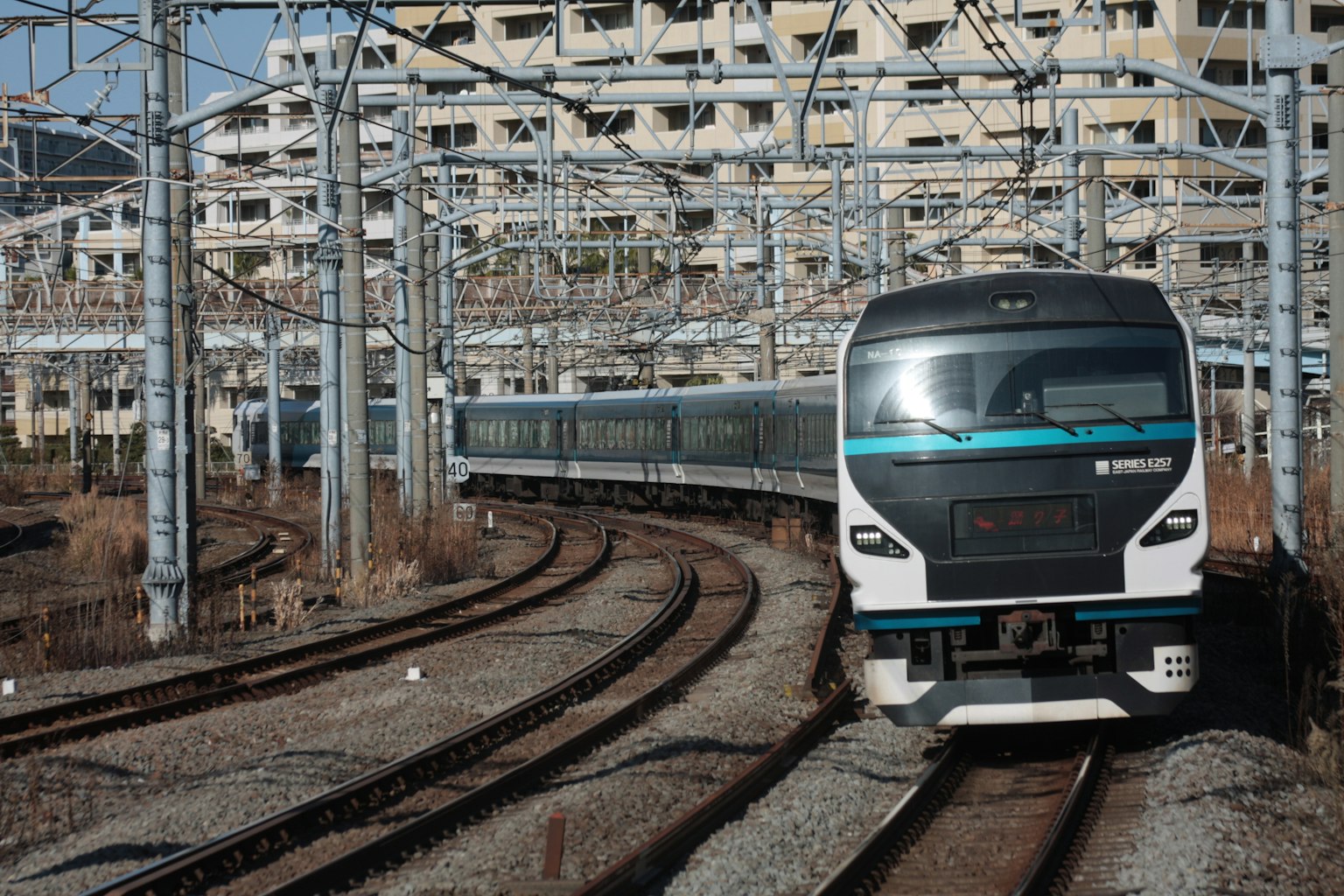 Treno moderno su binari curvi con edifici abbandonati sullo sfondo