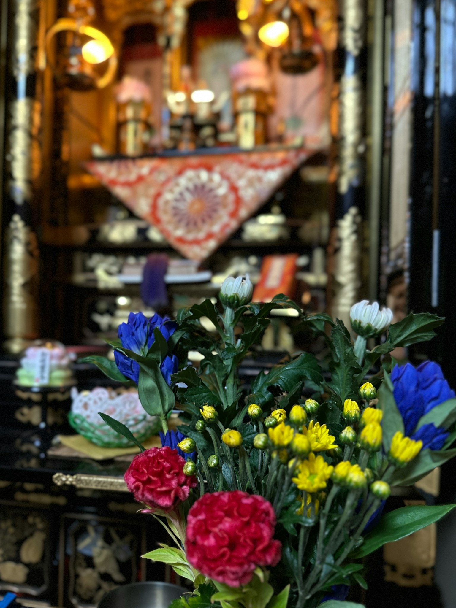 Vibrant bouquet of flowers in front of a beautifully decorated altar with golden accents
