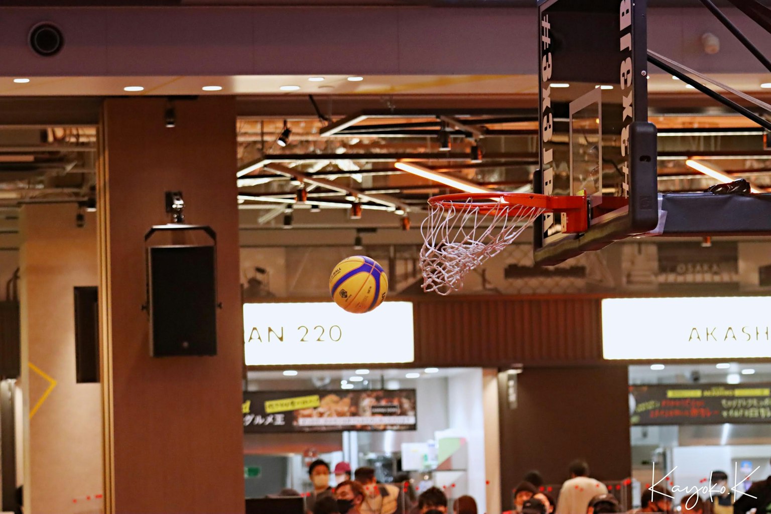 Adegan dalam ruangan dengan bola basket terbang menuju ring