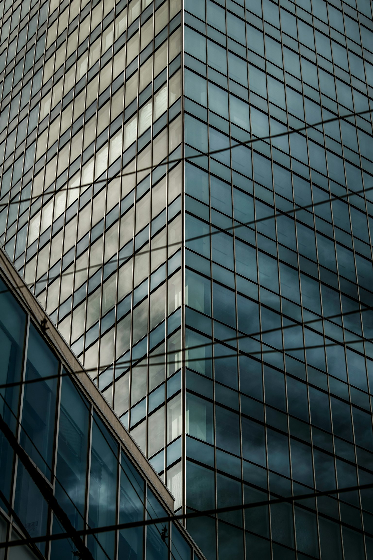 Bild einer Ecke eines Glasgebäudes mit vertikalen Linien und Reflexionen