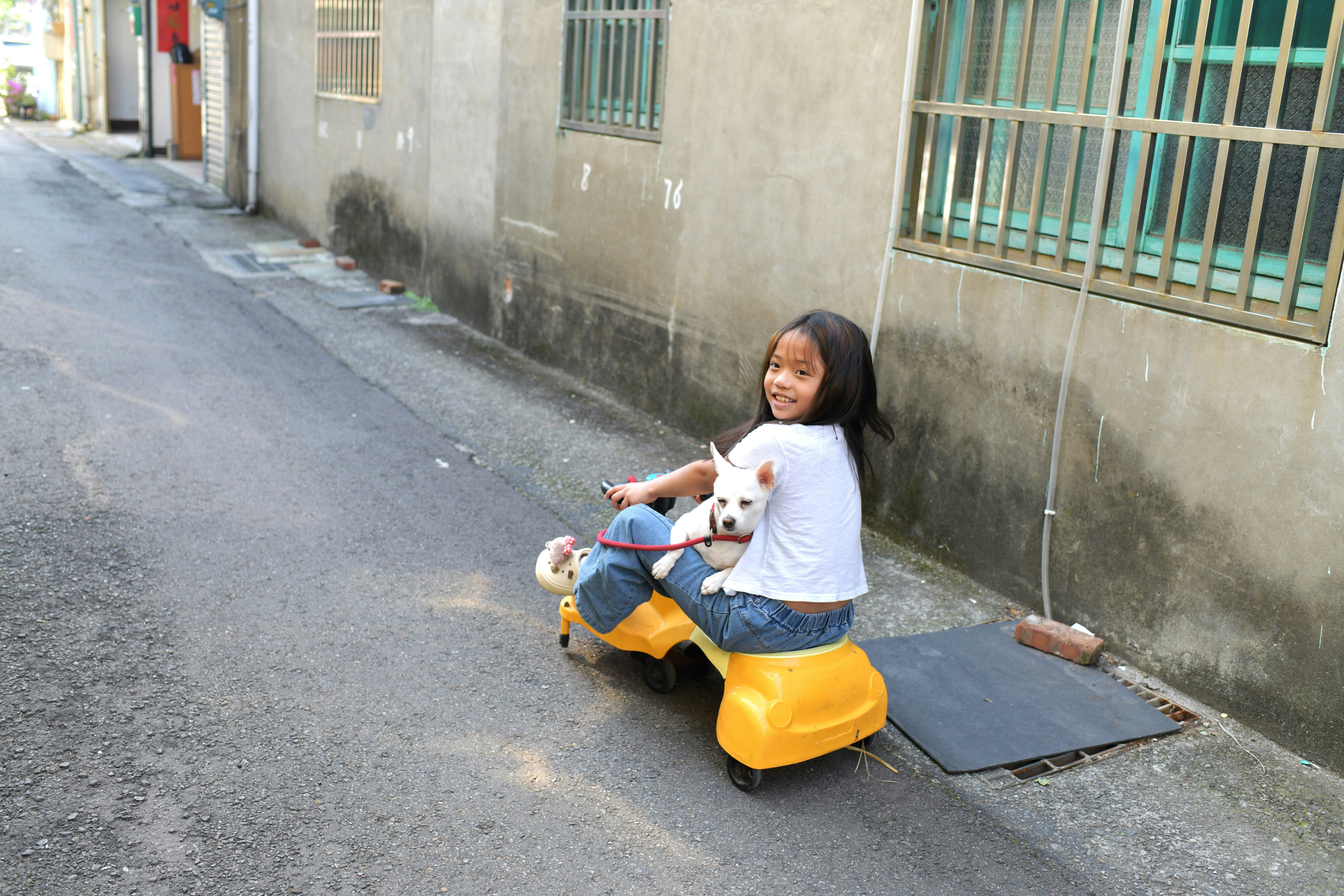 路地で遊ぶ子どもとぬいぐるみ