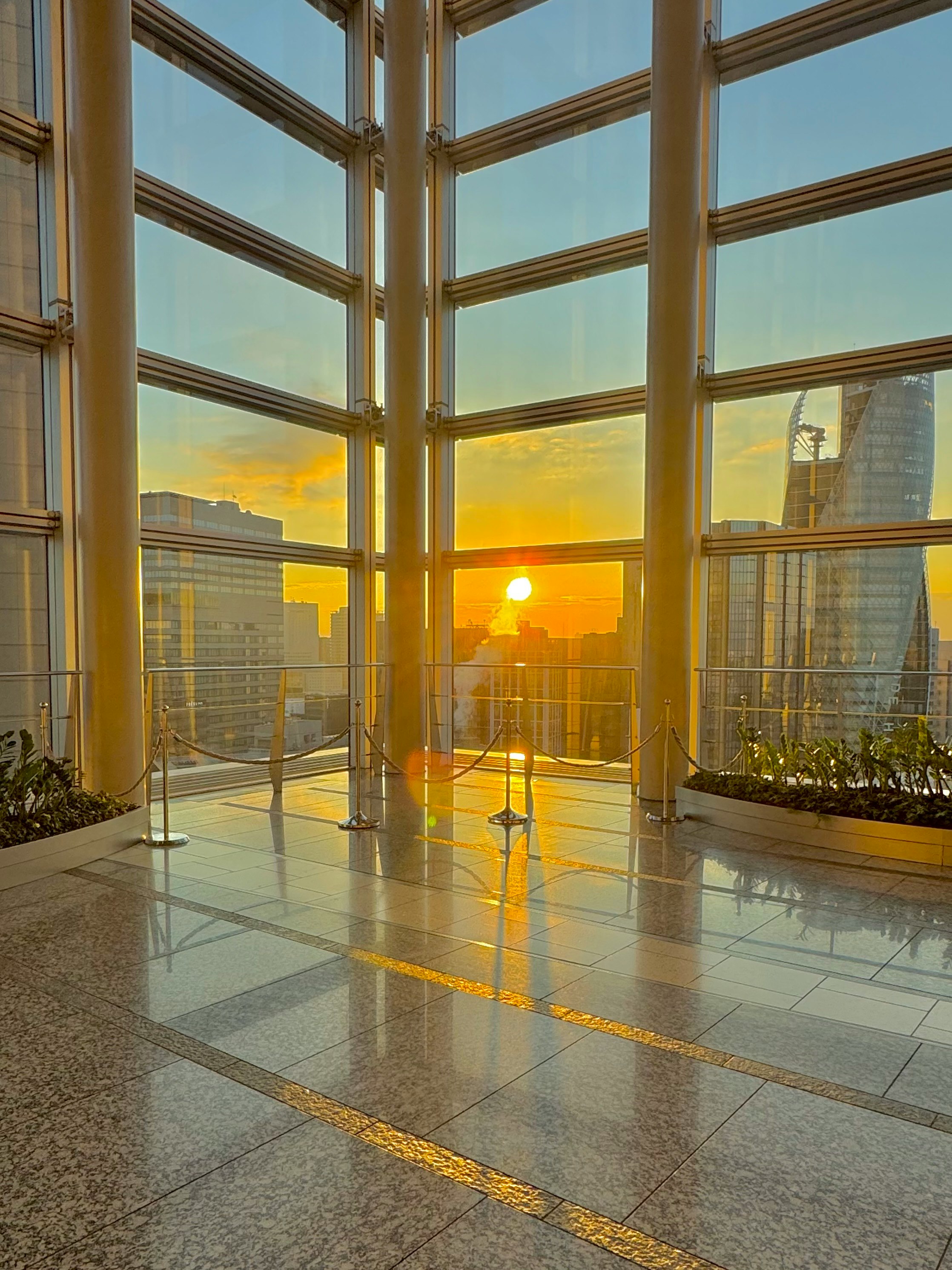 Vista del atardecer a través de grandes ventanas en un edificio moderno