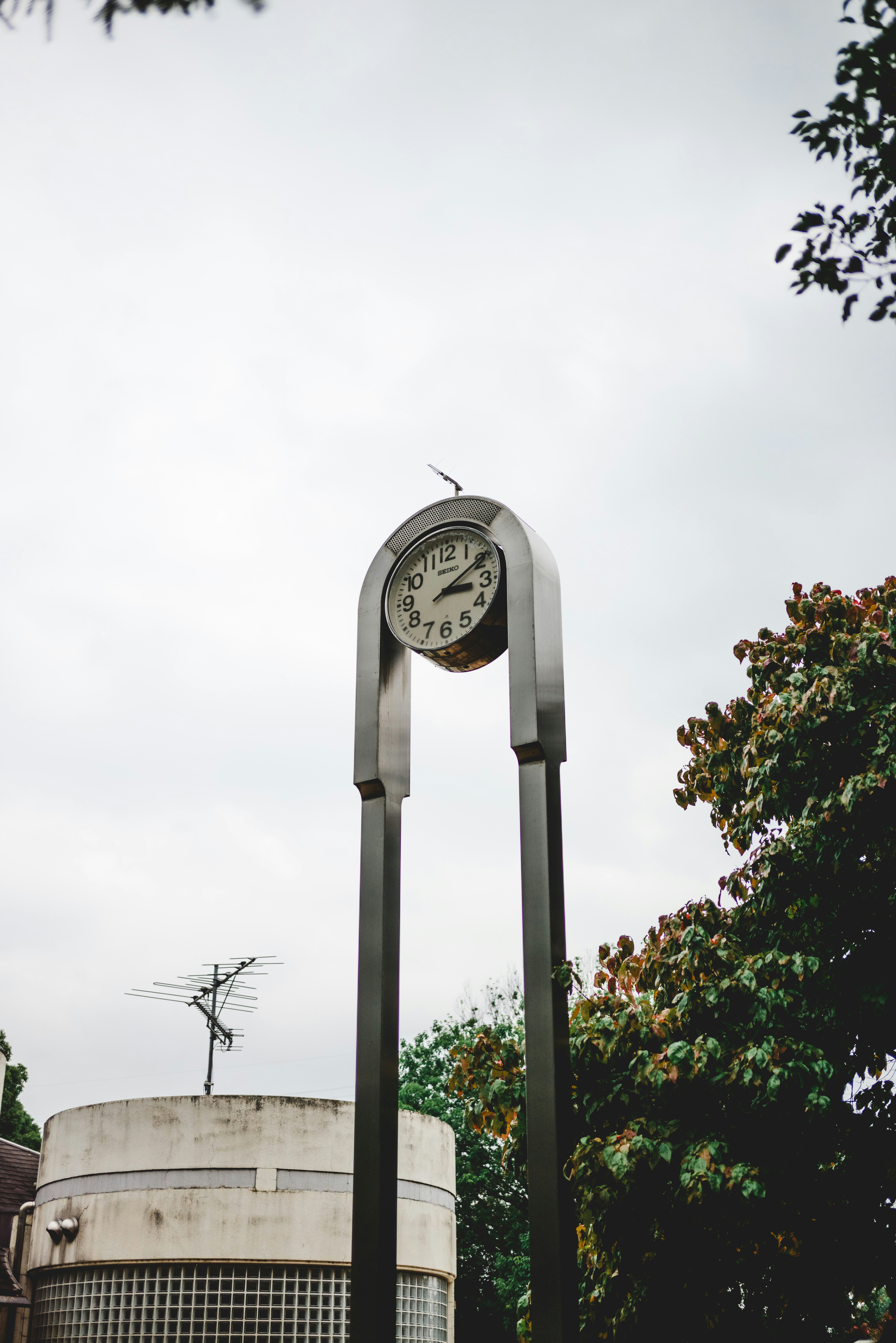 outdoor arch thermometer against an overcast sky