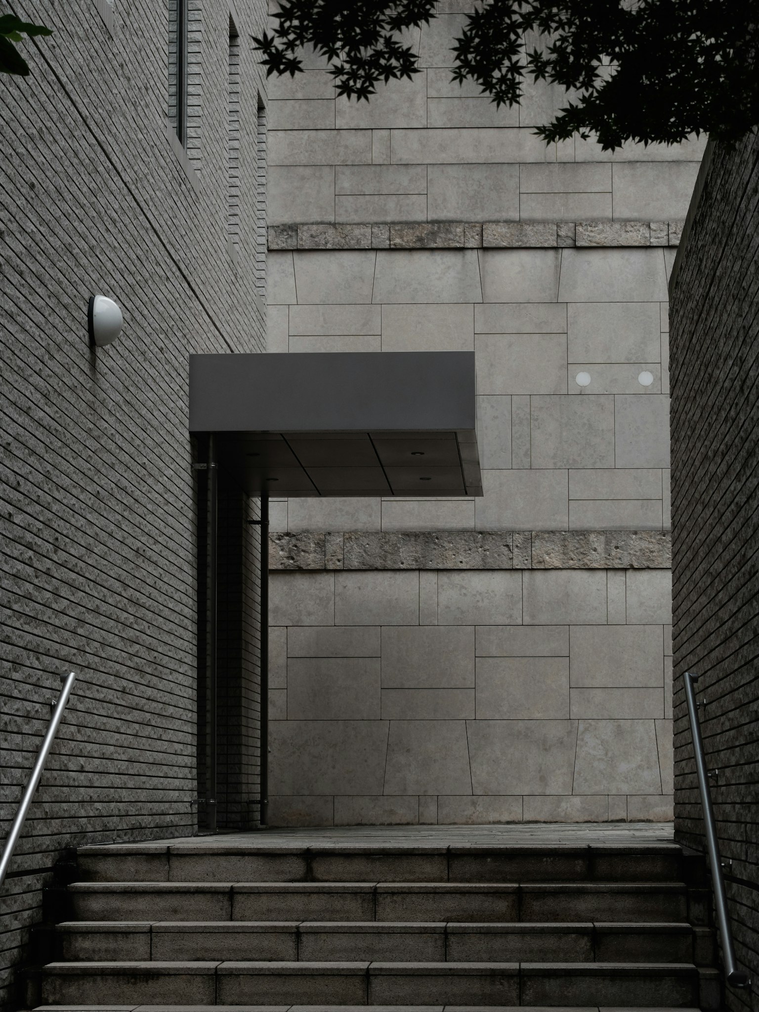 Modern building entrance at the top of a staircase Gray tiled walls create a minimalist look