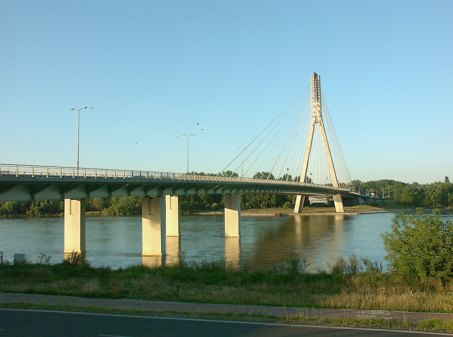 Moderner Hängebrücke über einen Fluss unter einem klaren blauen Himmel