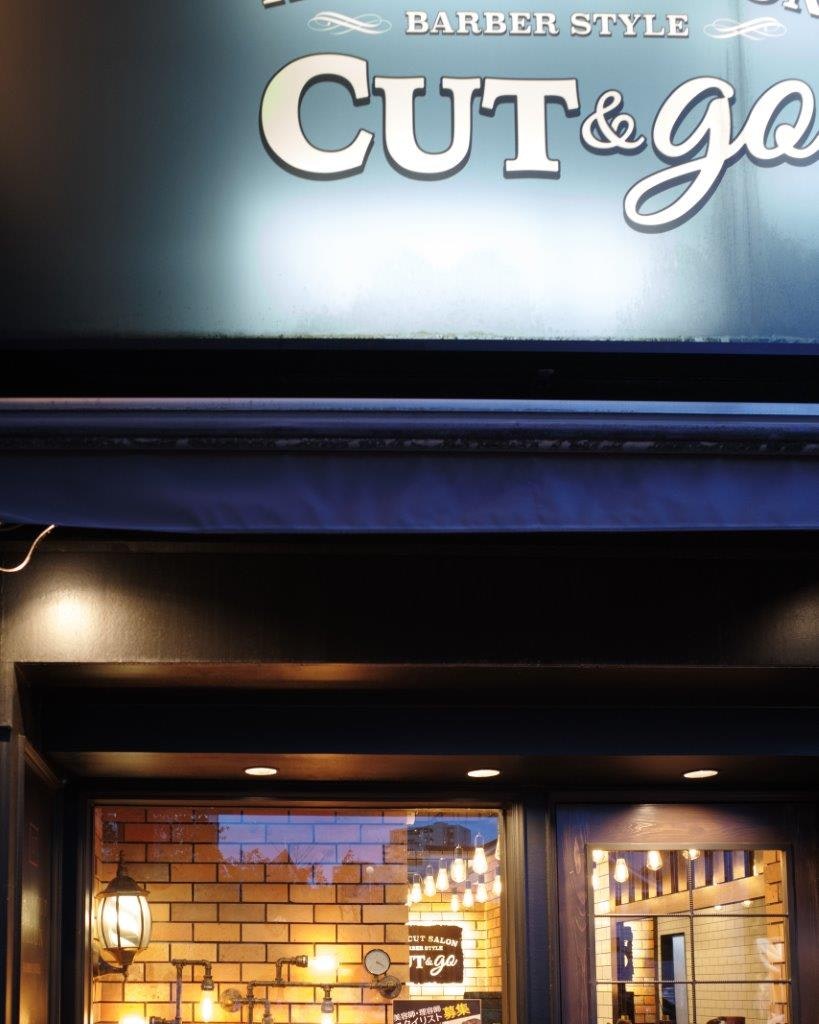 「CUT&GO」看板のある理髪店の入口