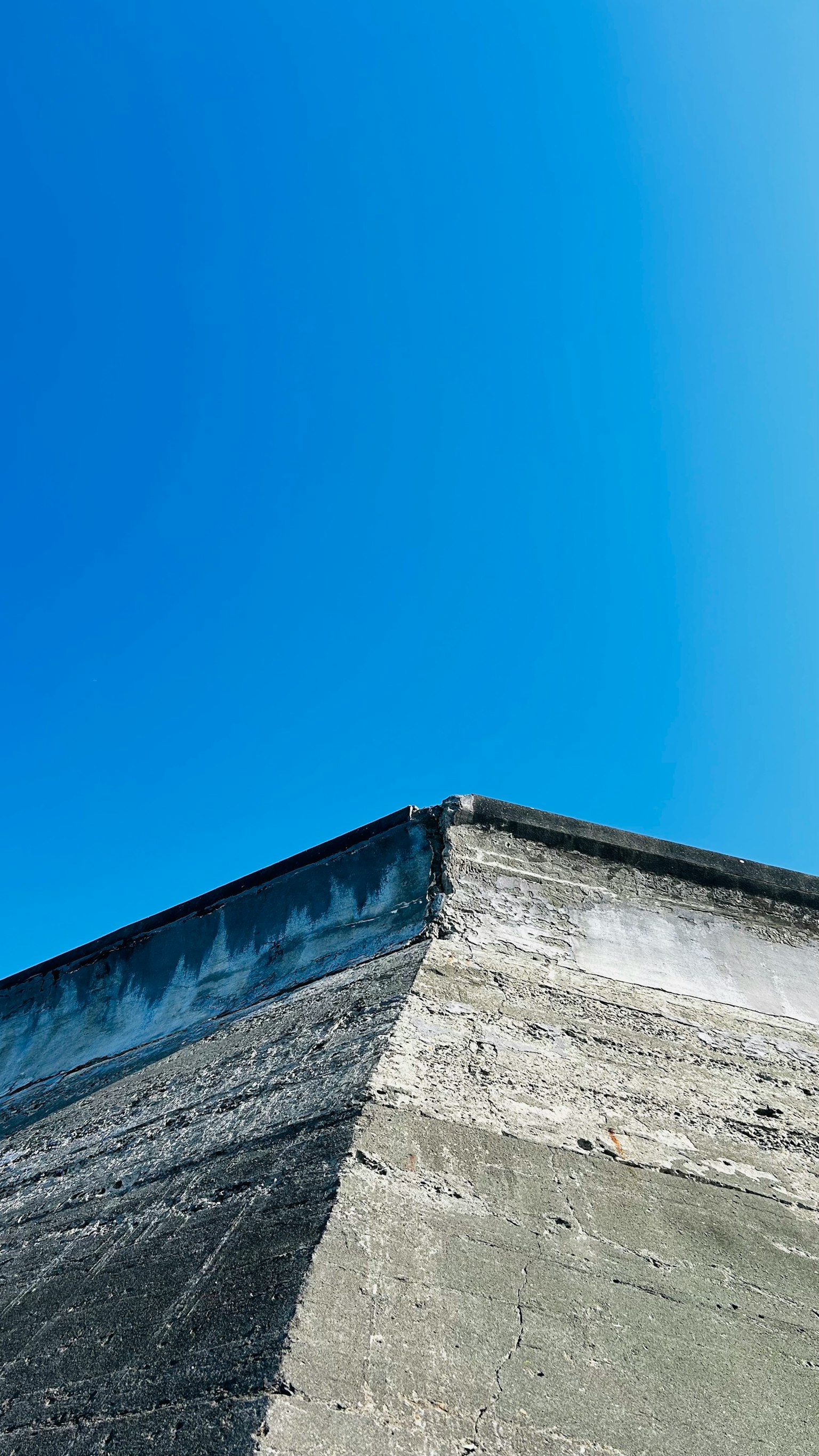 Esquina de concreto bajo un cielo azul claro