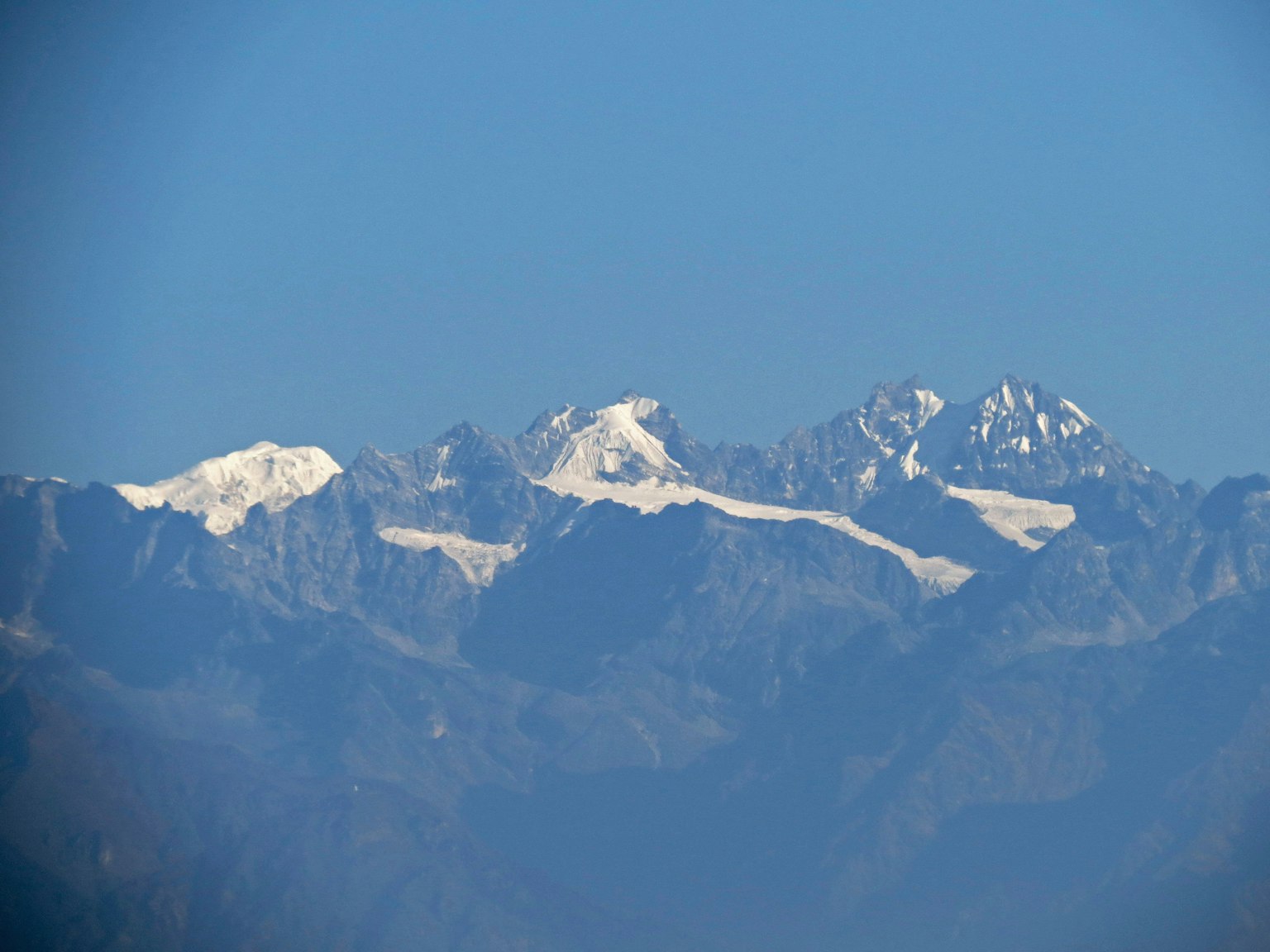 Montagne innevate sotto un cielo blu chiaro